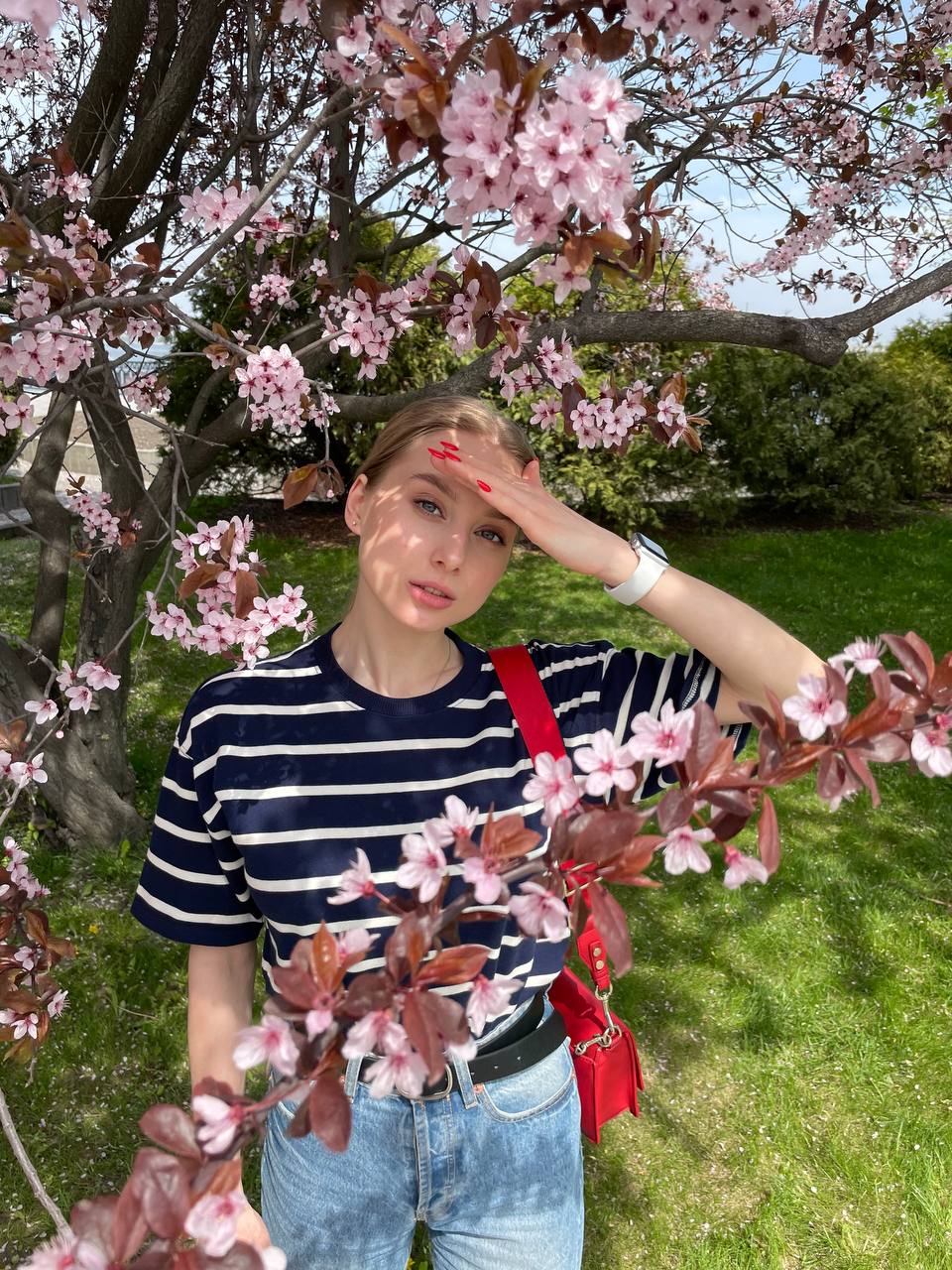 Woman working on a laptop computer at a table in a bright room.