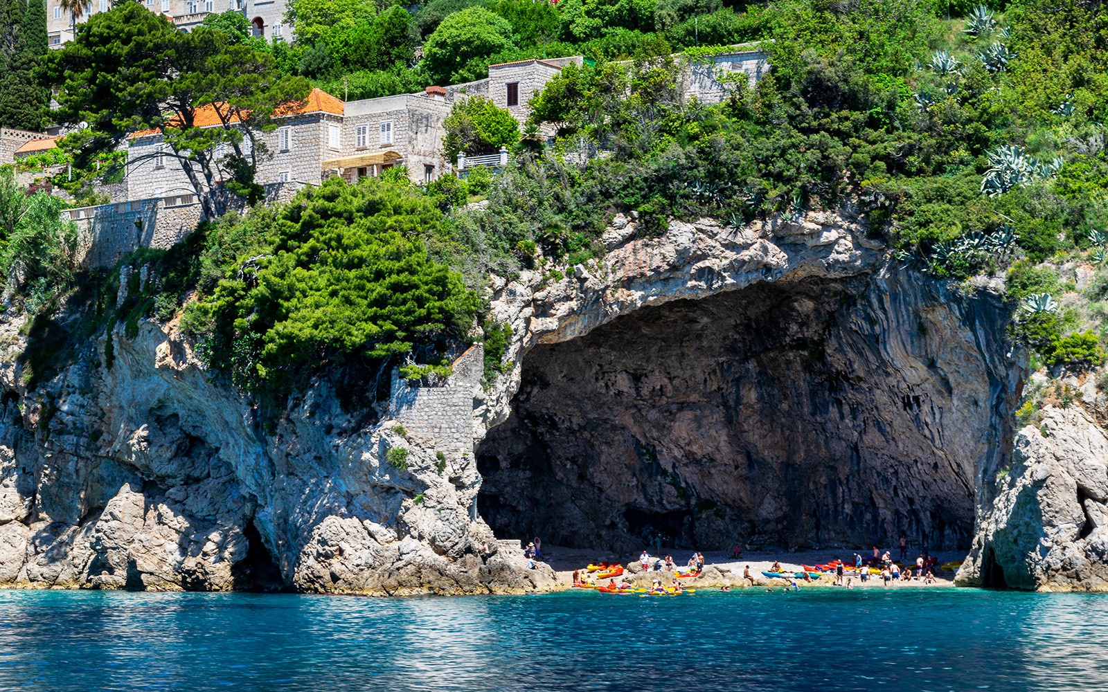 Kayakers and visitors at Betina Cave Beach, Dubrovnik, Croatia.