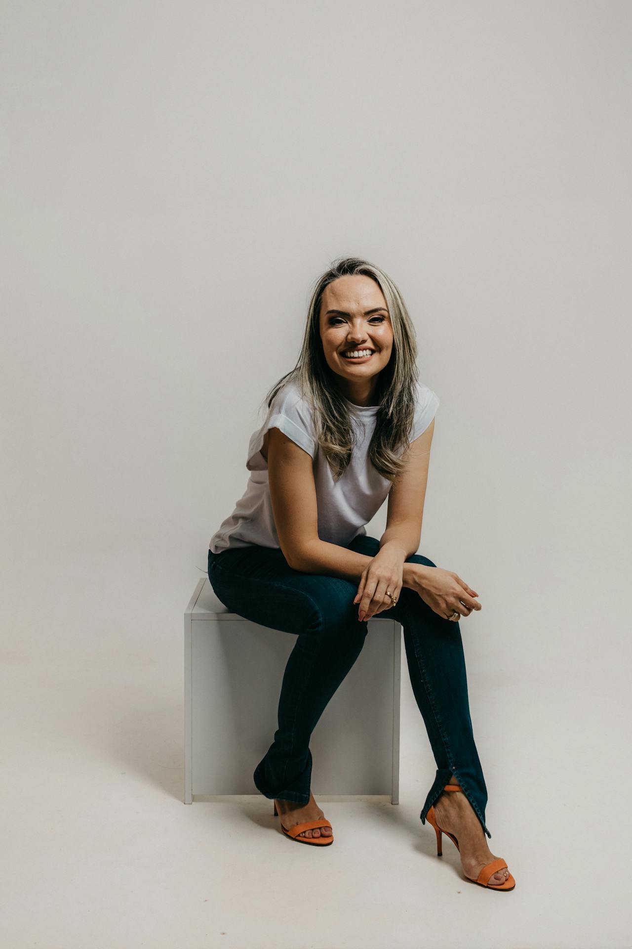 a women with grey t shirt sitting on a bench smiling