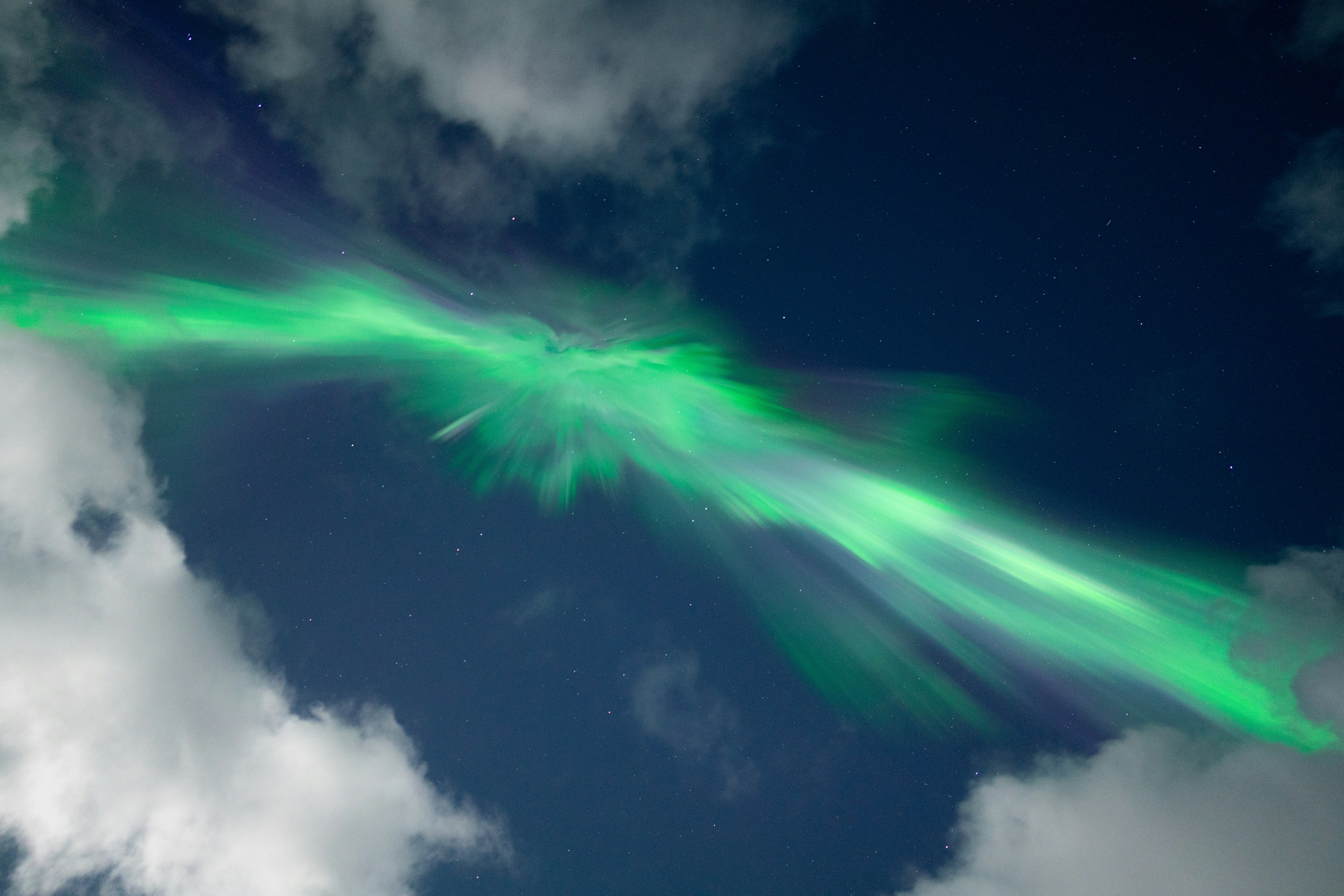 Green aurora borealis dances across a starry night sky.
