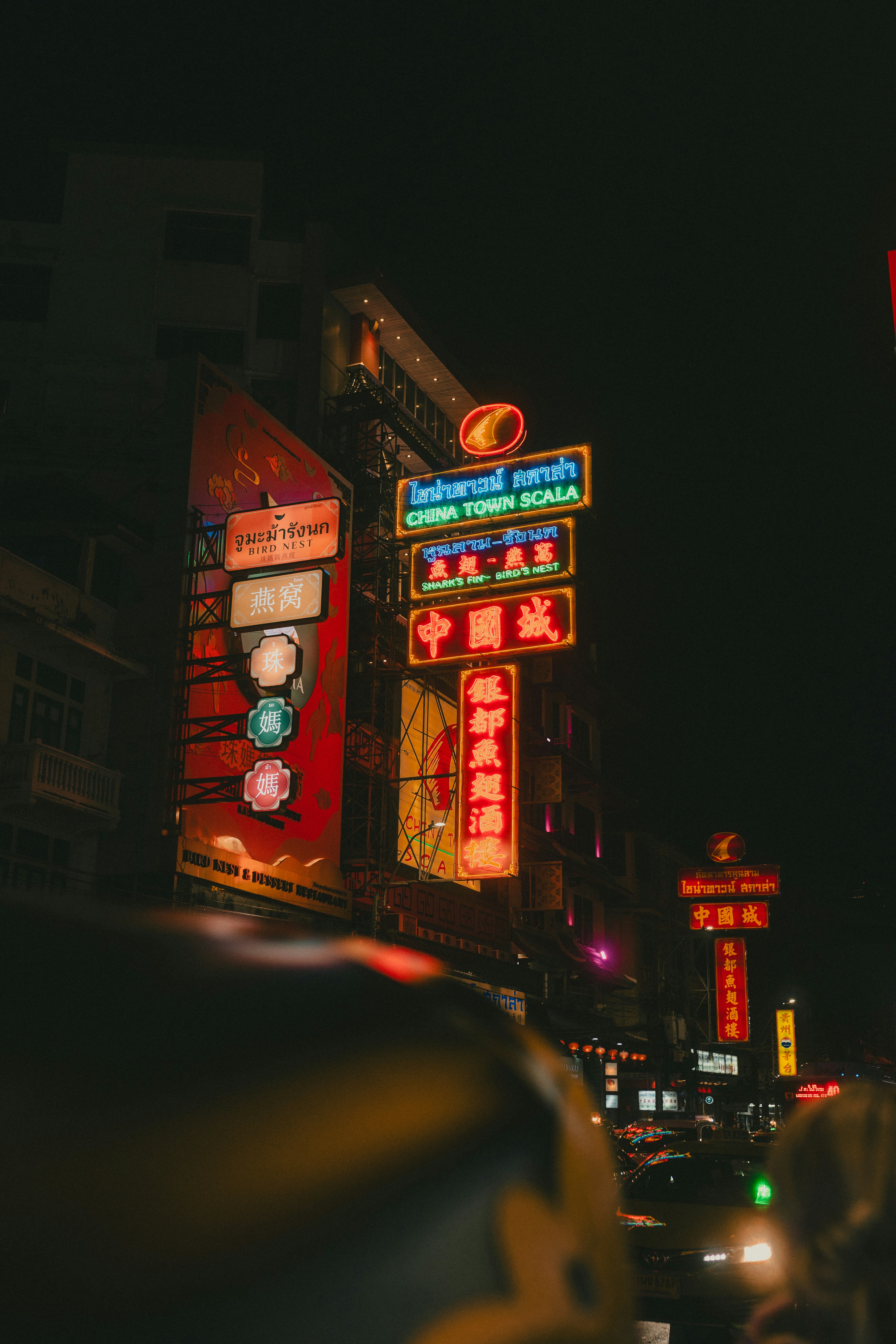a busy city street at night with neon signs