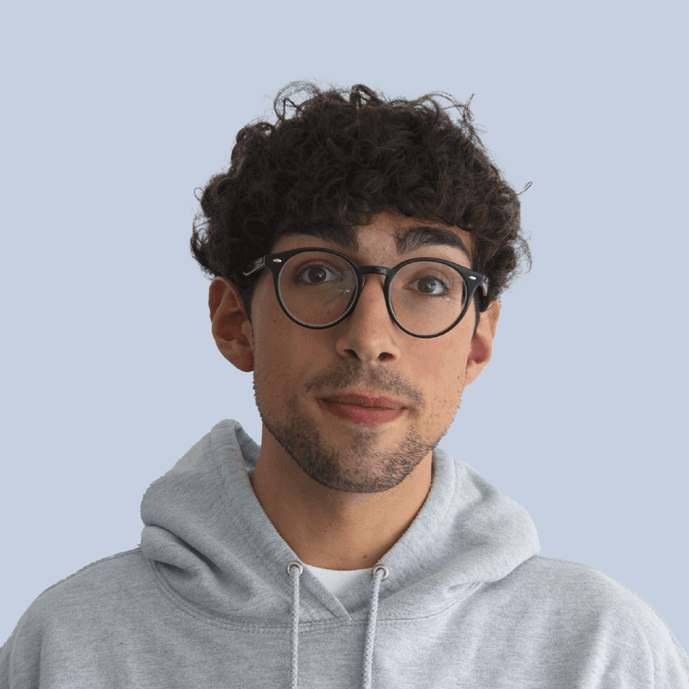 Portrait of a person in a pink sweater against a light background