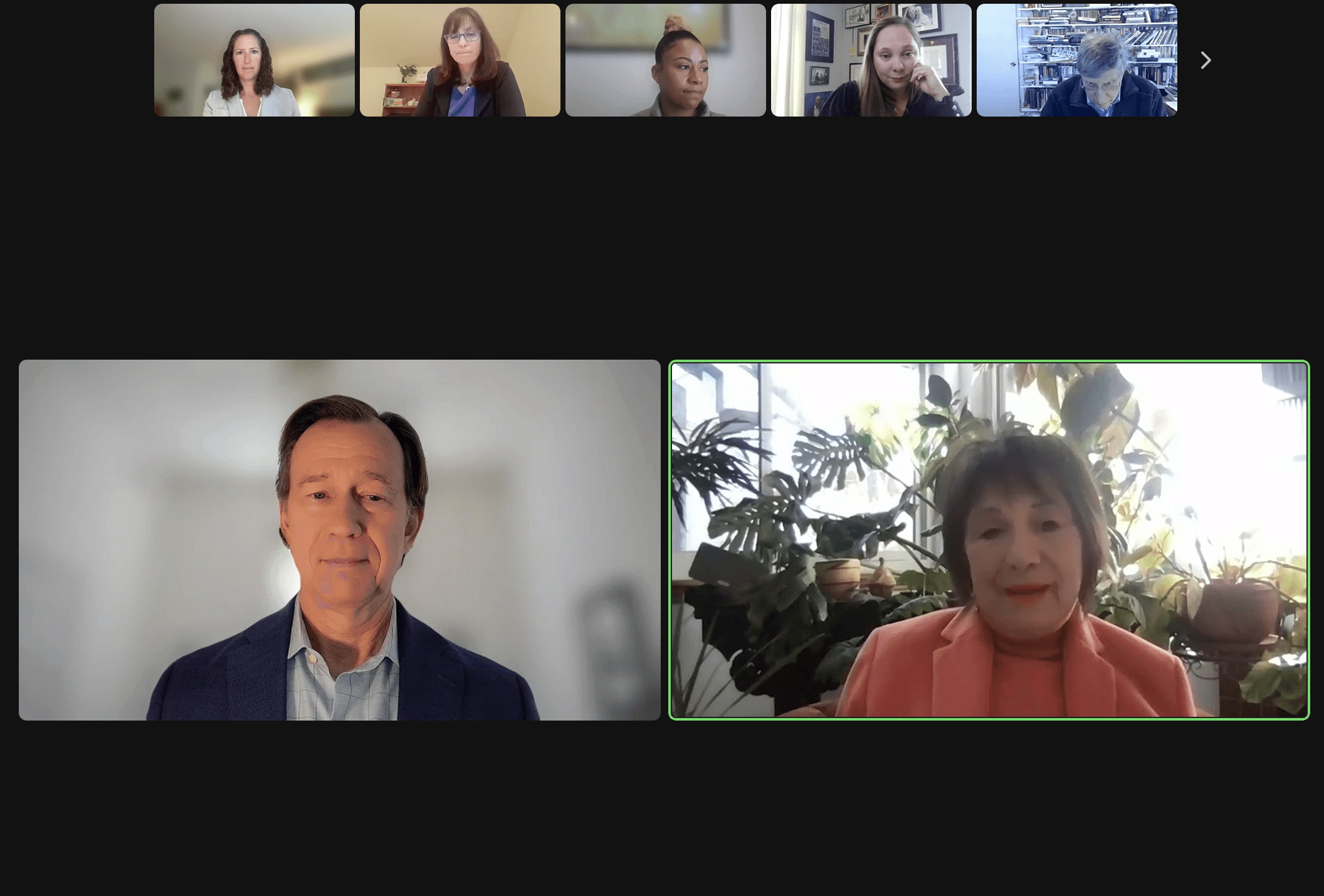 A virtual meeting screen showing two participants in a video call, with others in smaller windows above.