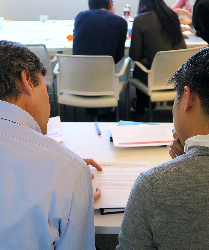 The back of two people as they converse with each other.