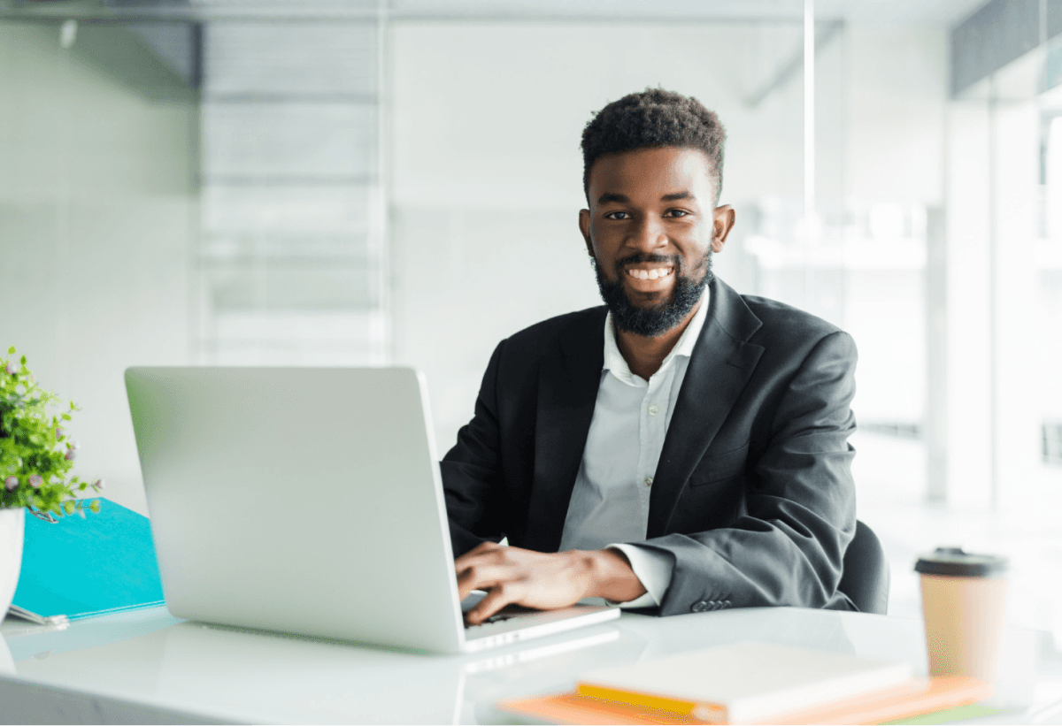 african man smiling and using laptop