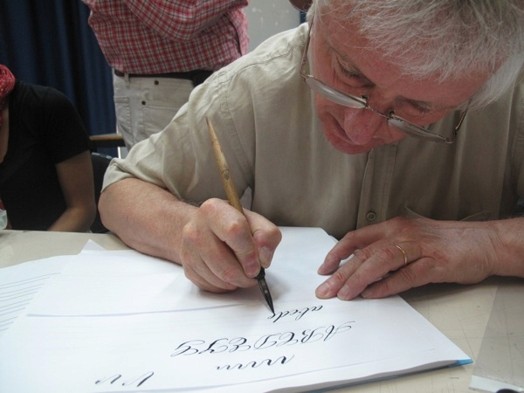 A teacher showing the students how to draw letters by hand.