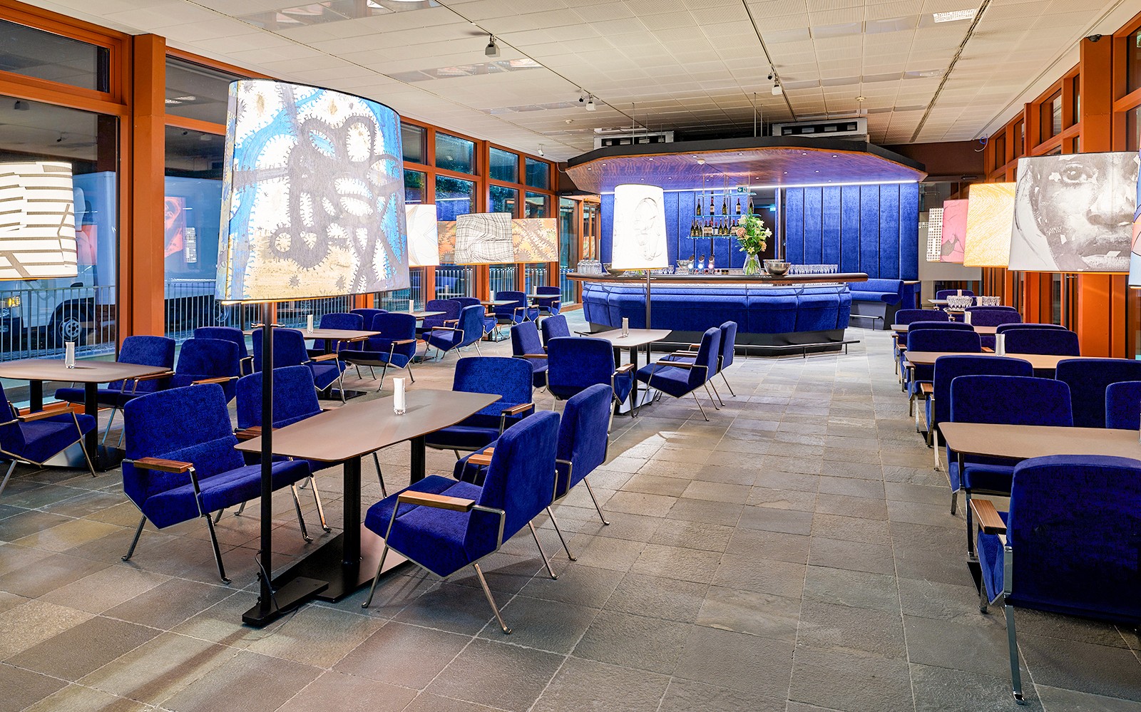 Contemporary art-themed café interior at Belvedere 21, Vienna, with blue seating and artistic lamps.