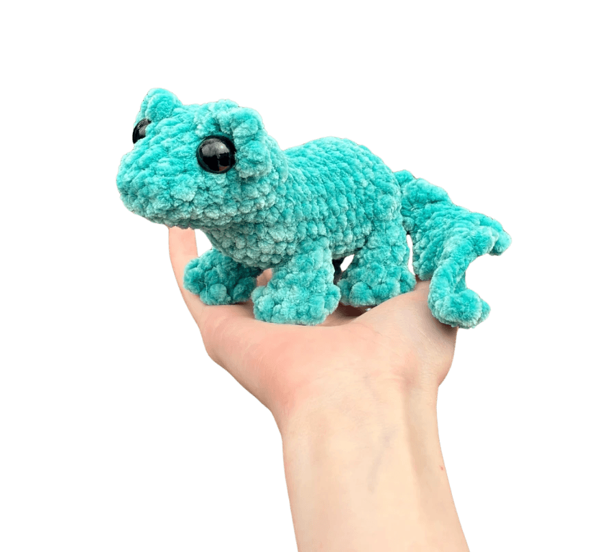 A cute, handcrafted plush acorn toy with brown yarn spikes and large, friendly eyes sits facing forward on a white background.