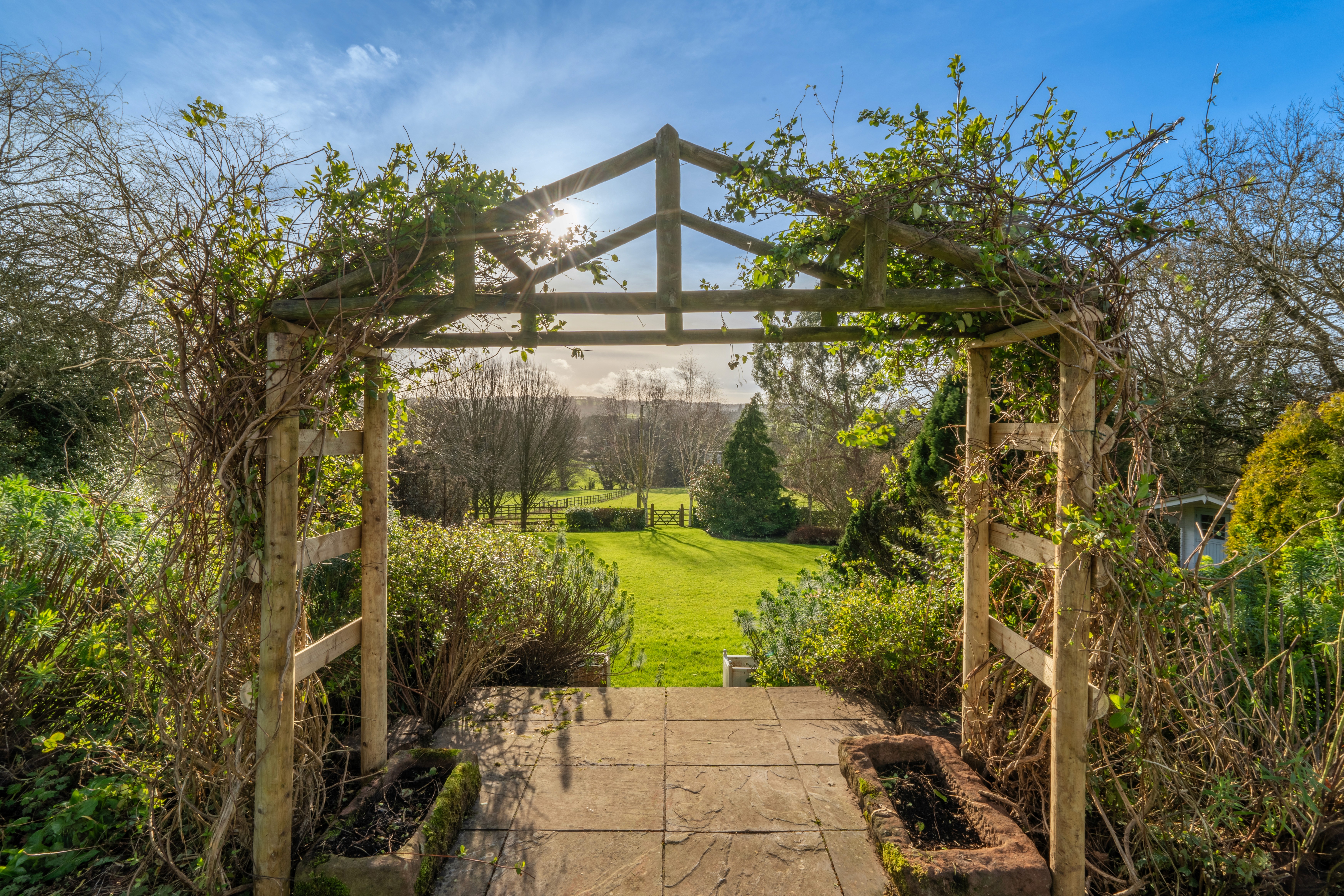 Garden pergola overlooking lawns at Washbourne Cottage
