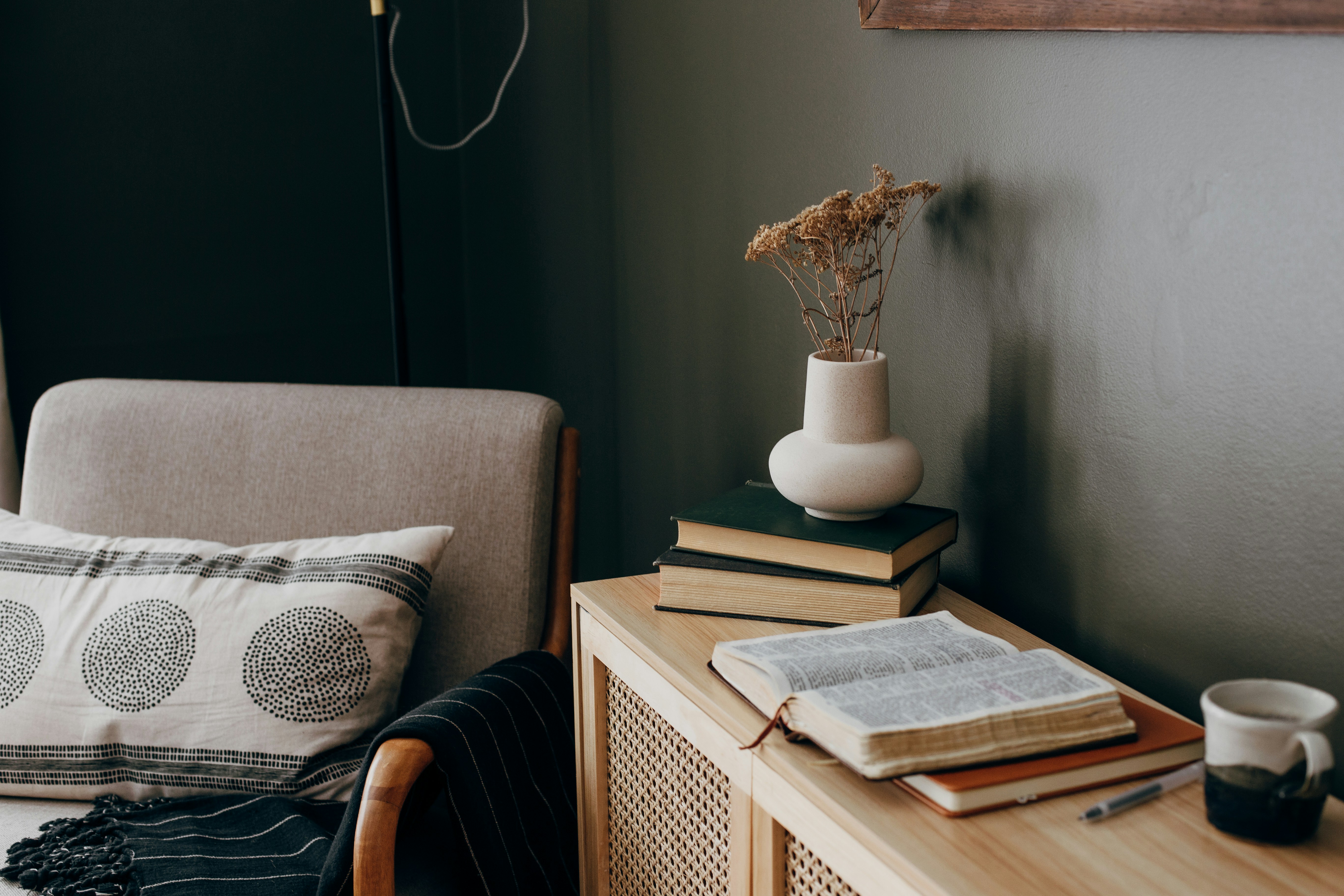 a chair, cabinet, and plant pot in a living room