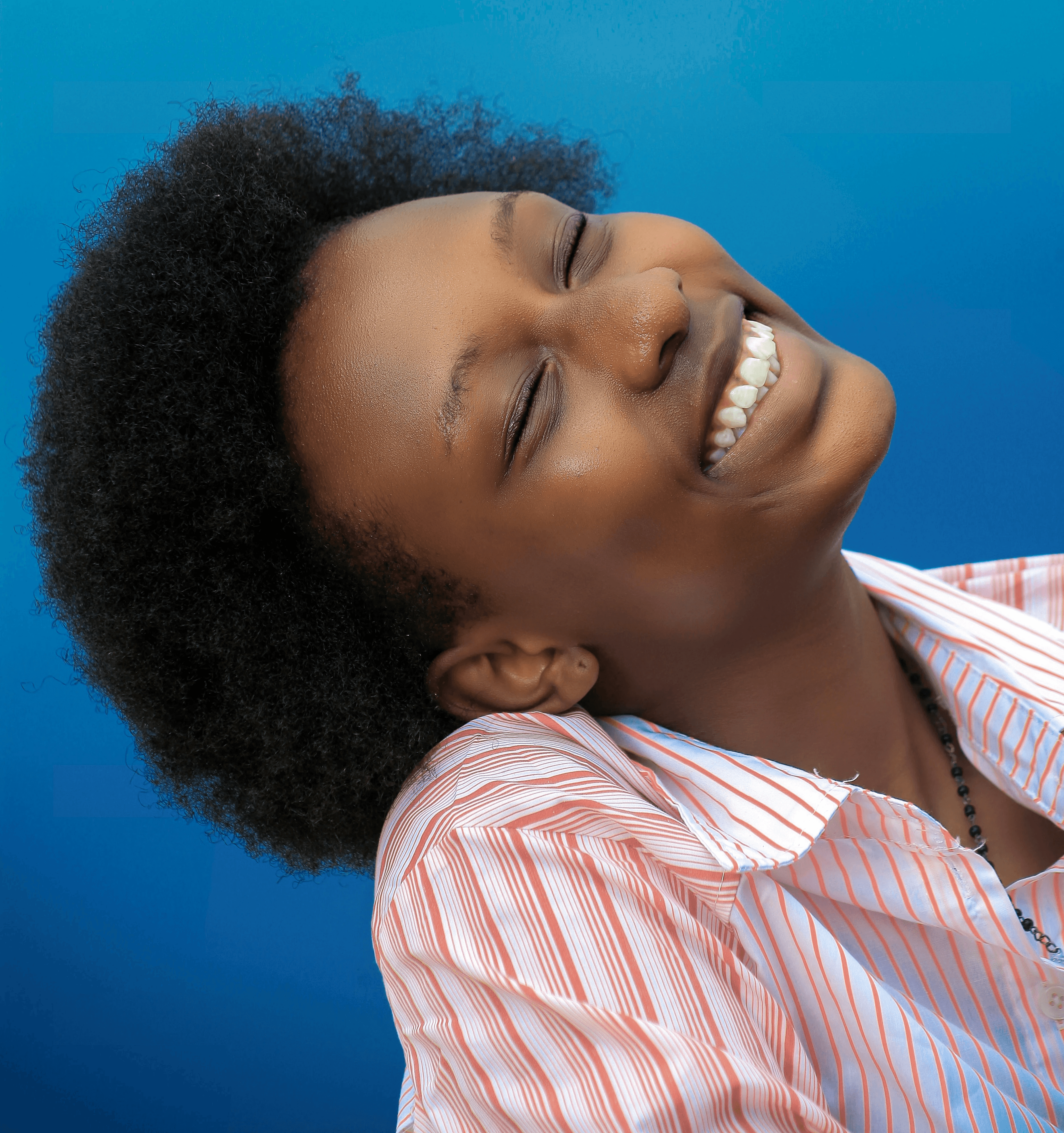 smiling girl in pink and white stripe shirt