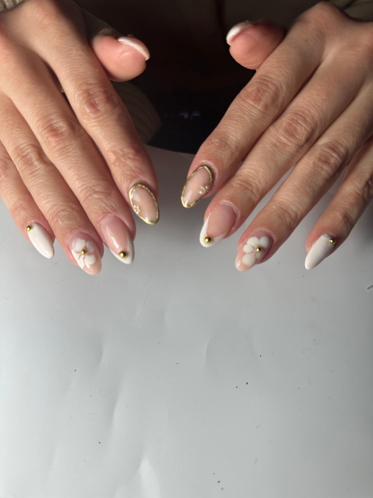 Hand with pink swirl nails and rings in car