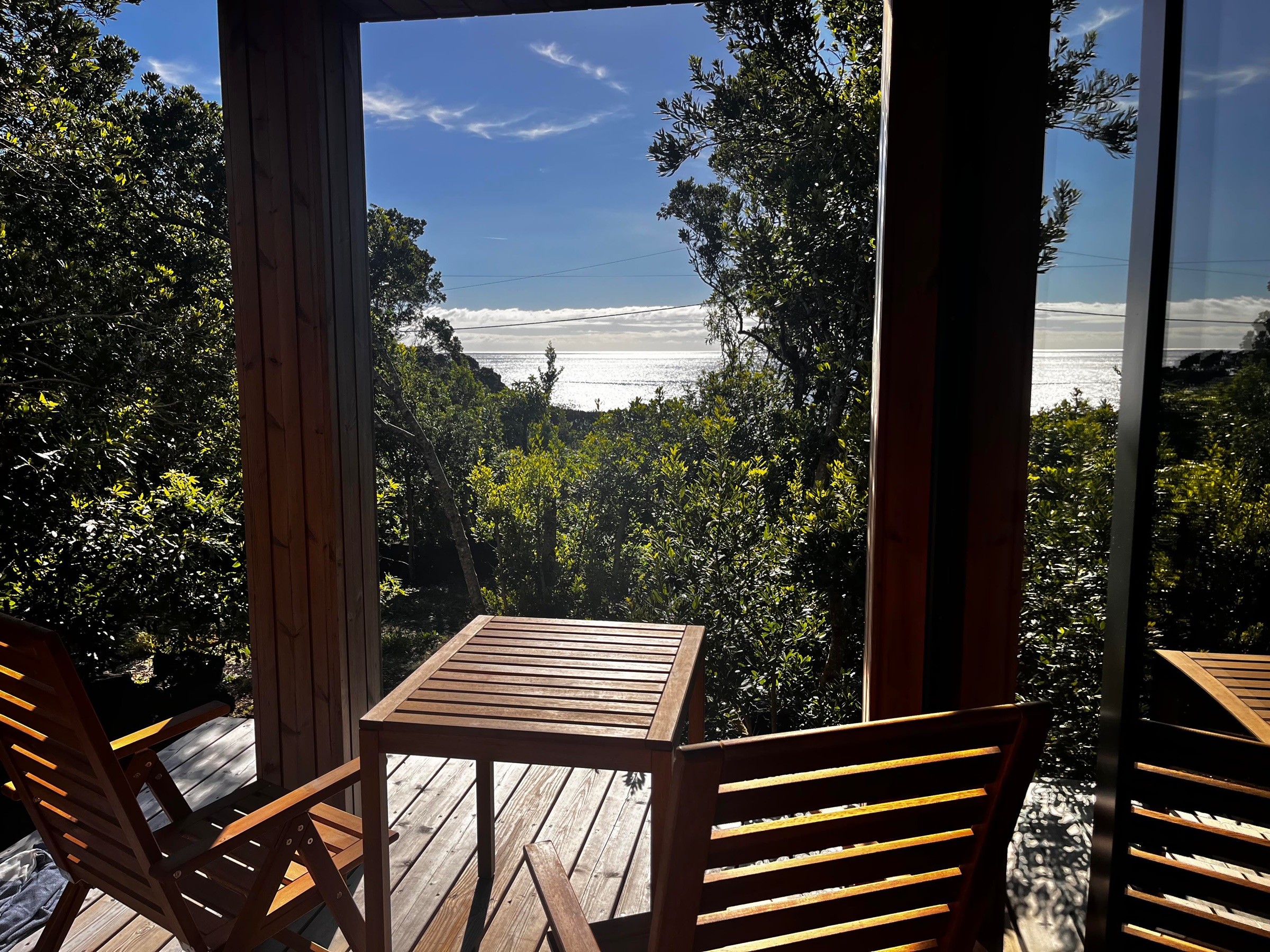 Ocean view framed by surrounding trees, seen from the deck at Misterios Lodge