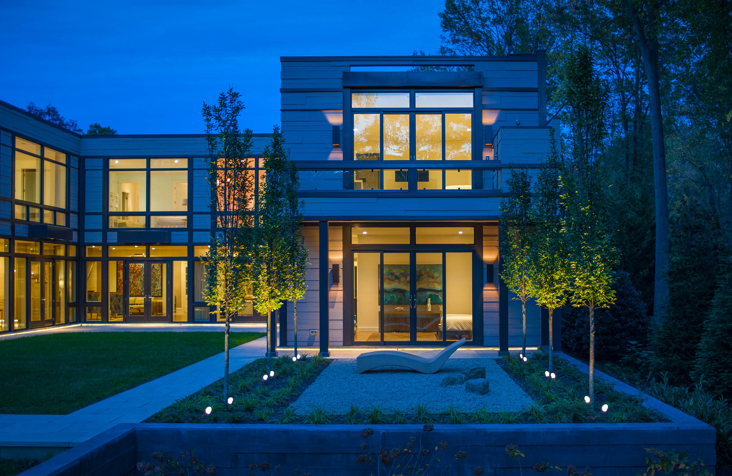Expansive glass panels dominate the facade, creating a seamless connection between the interior and exterior.