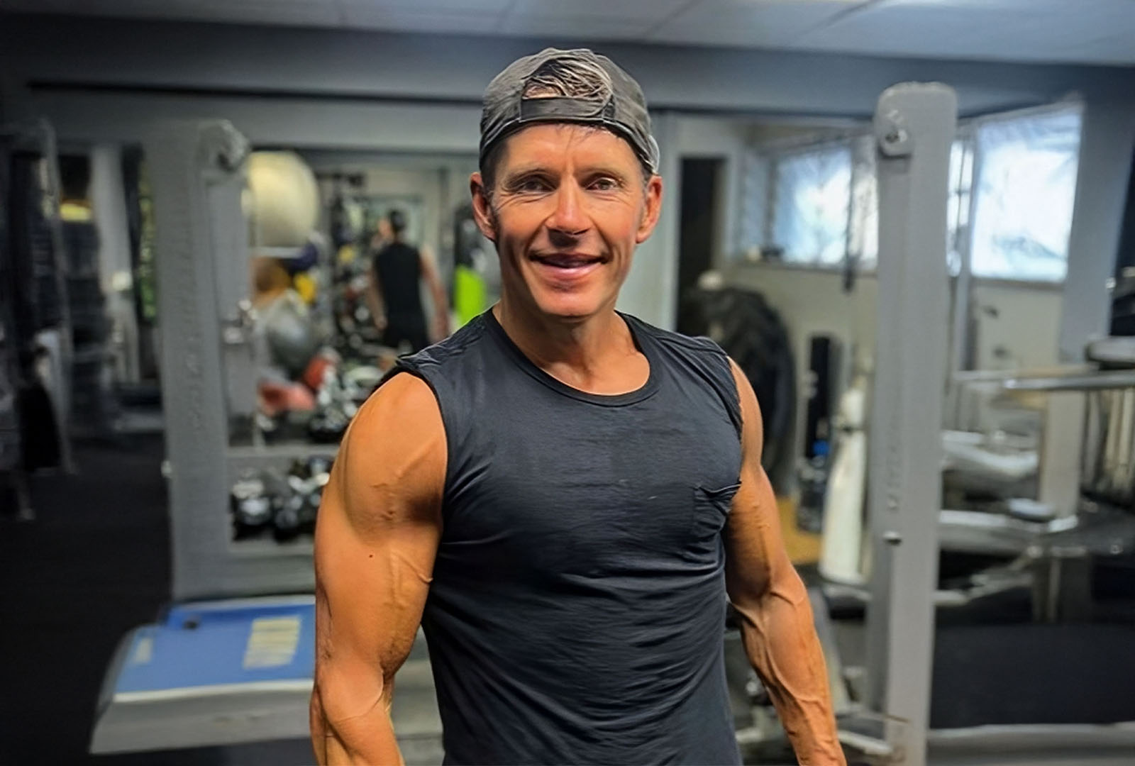 Close-up of lush, dark green leaves, some glossy and wet, against a muted background.