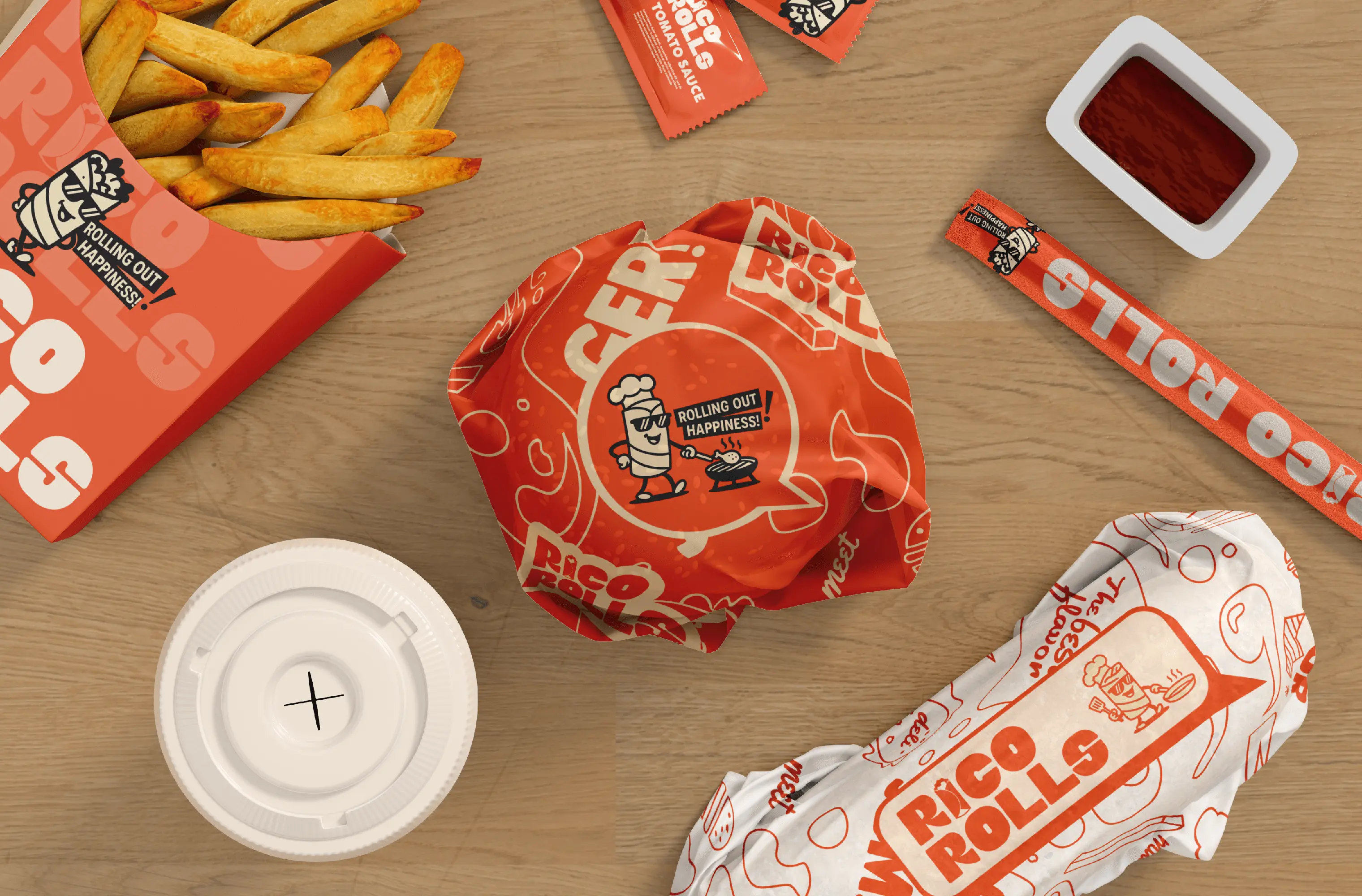 Rico Rolls branded fast-food packaging laid out on a table, including fries, burger wrap, roll wrapper, sauce packets, and drink lid, featuring the Rico Rolls mascot and bold orange brand graphics.