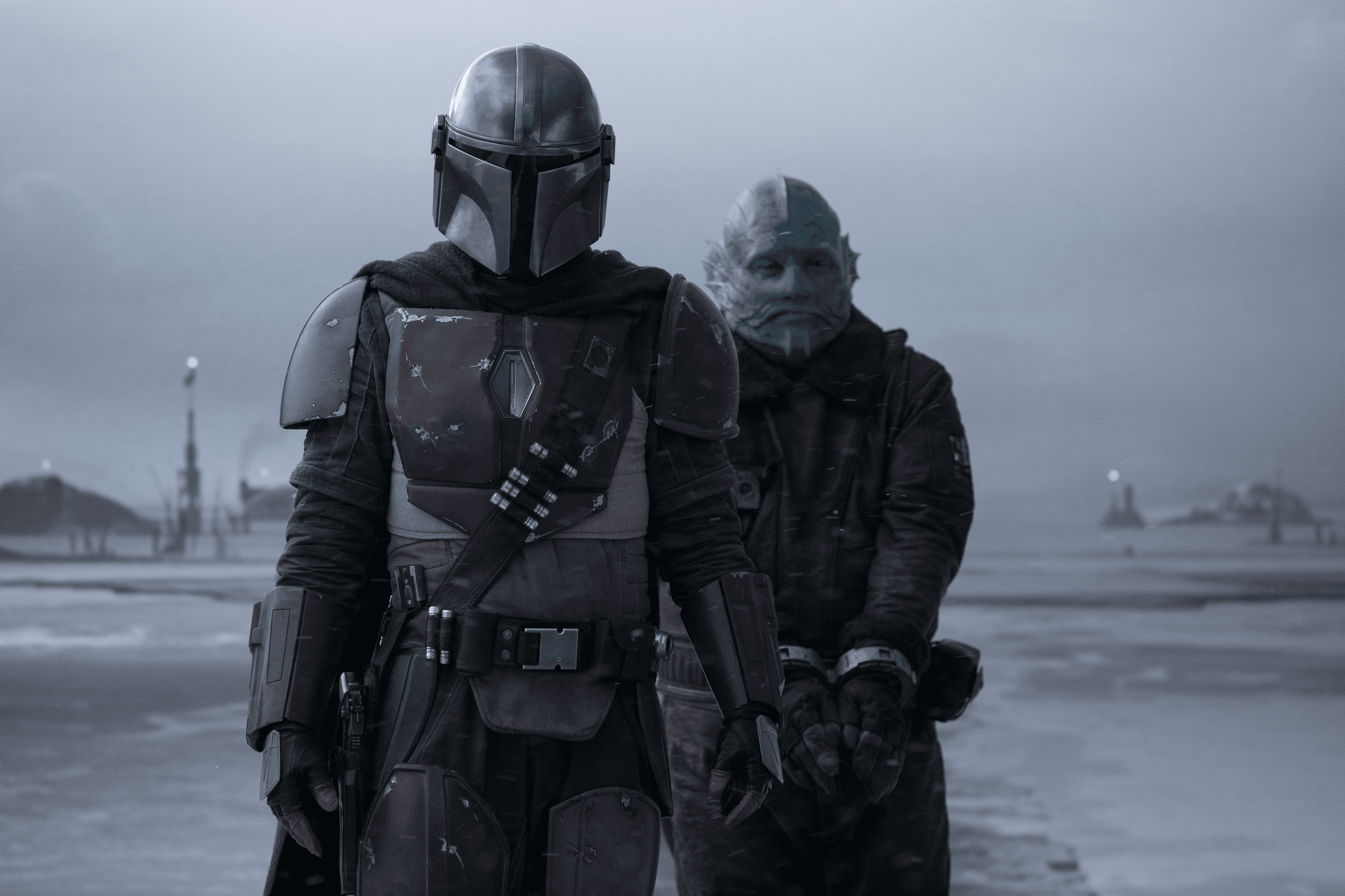 Two characters in armored suits walk through a snowy landscape, shrouded in a cold, grey atmosphere.