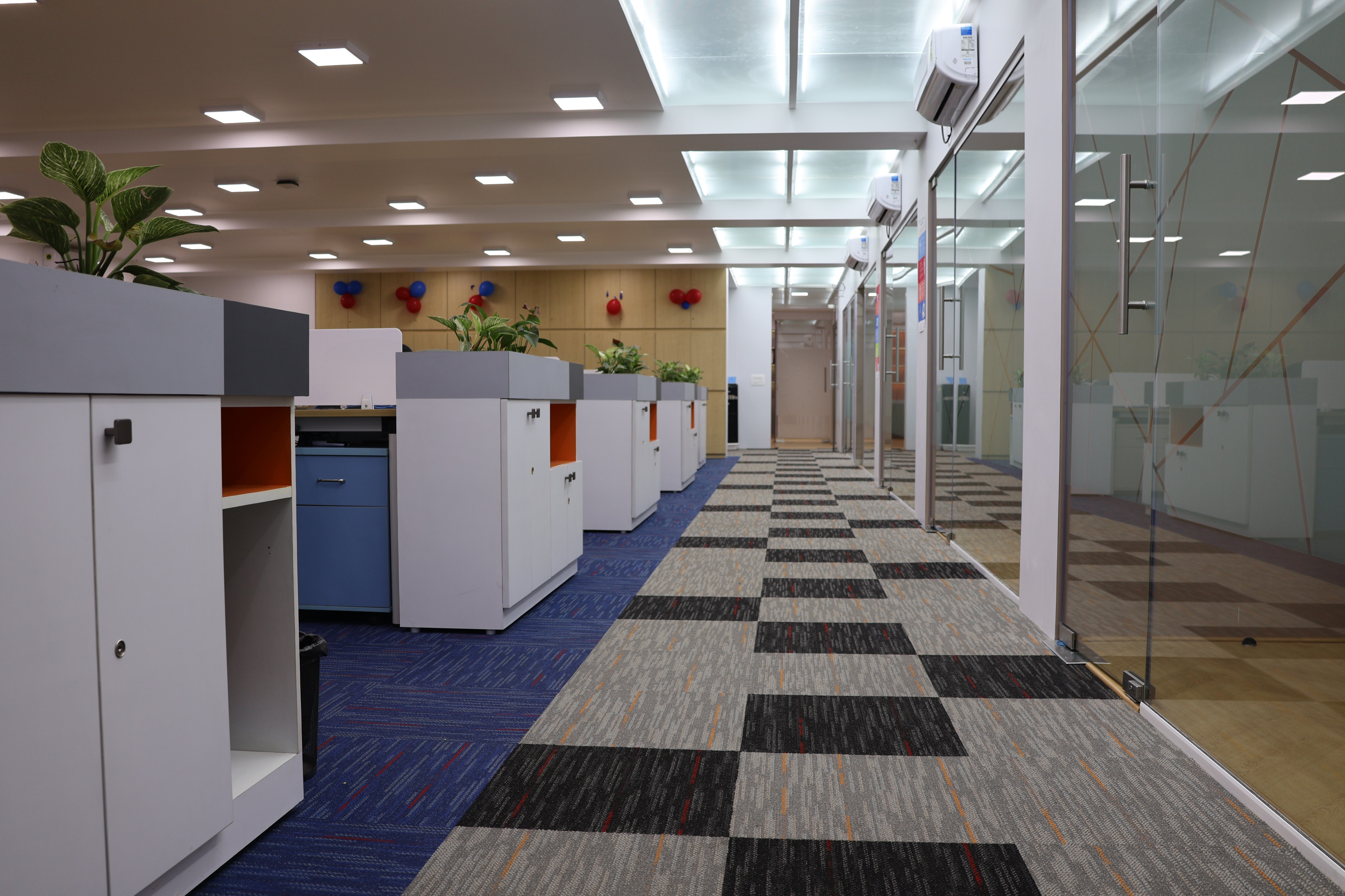 Modern office interior with desks and a hallway.