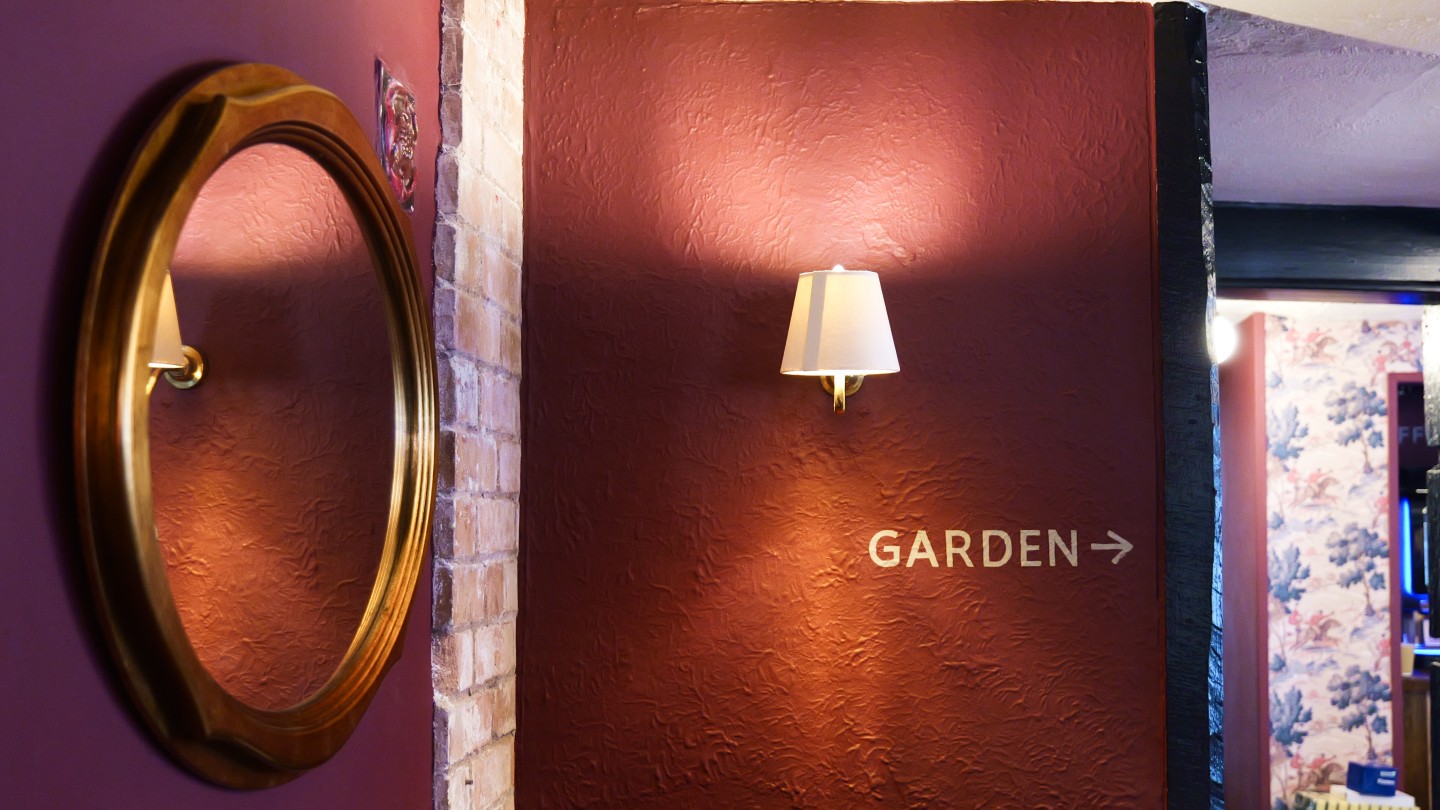 Warm wall light and garden signage at The Queens Arms Hereford, improving ambience, wayfinding and customer experience.