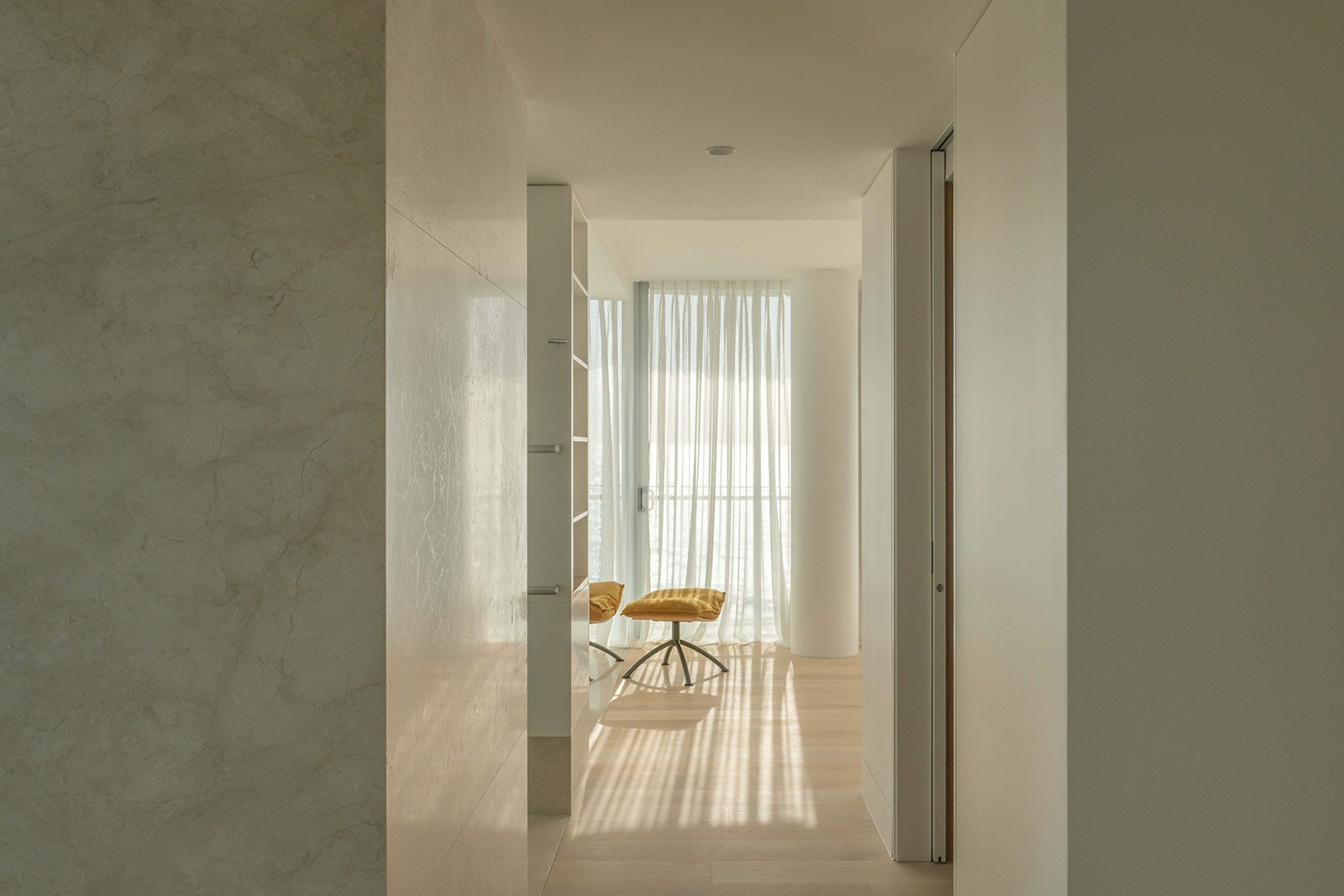 High Tide apartment corridor leading to bedroom retreat with filtered daylight, soft finishes, and coastal interior detailing.