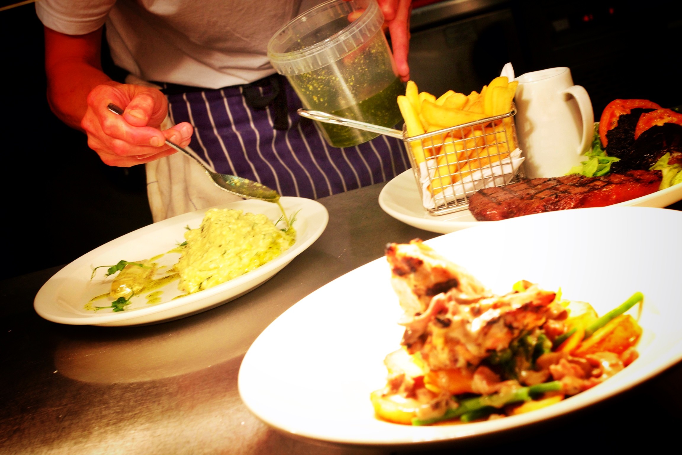 Chef plating up food in the kitchen of The Norton Dog