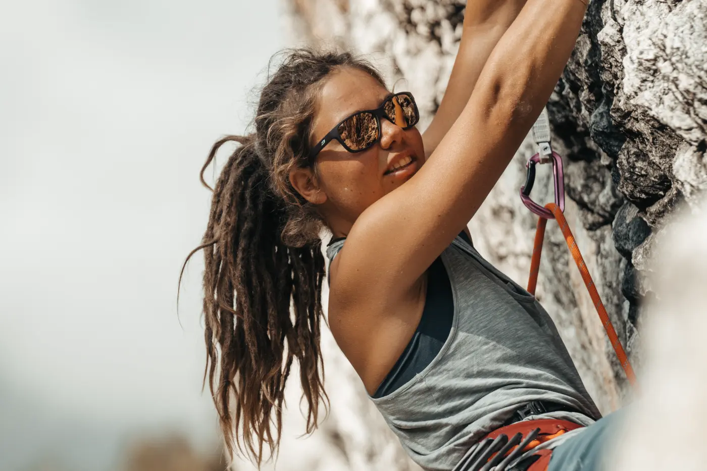 Femme escladant une falaise équipee de lunettes