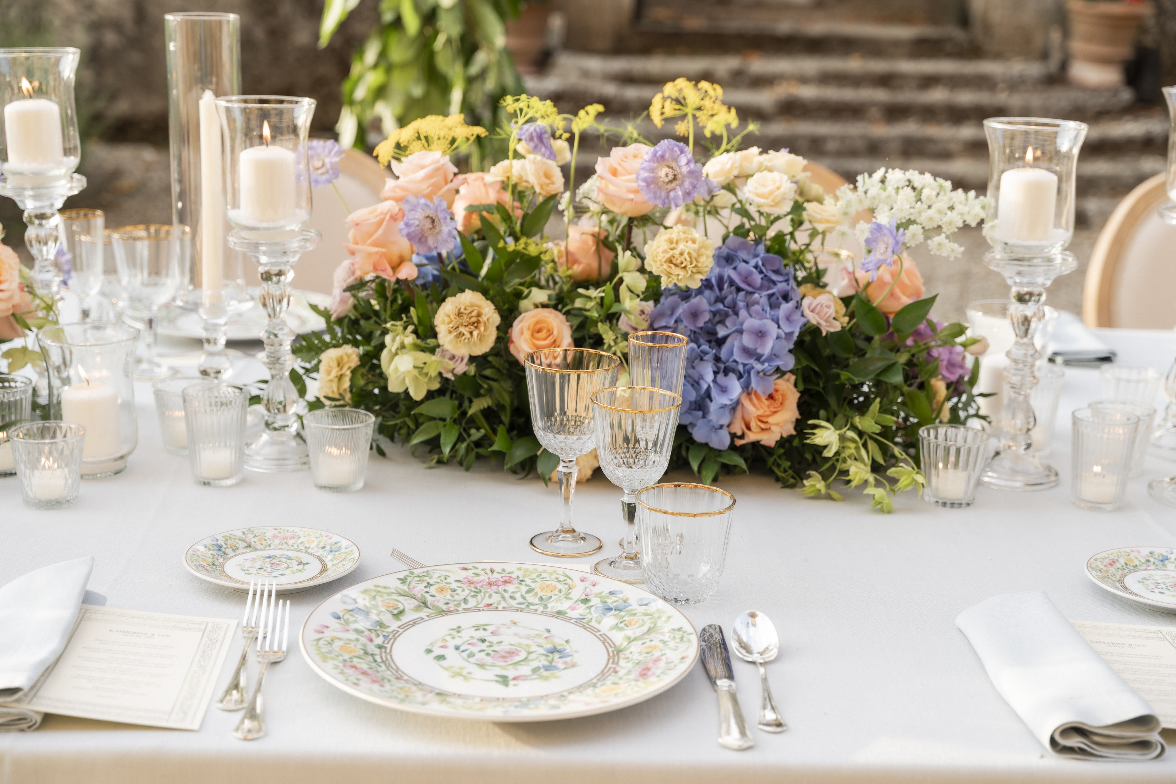 Allestimento tavolo per matrimonio a Firenze, catering di lusso con fiori freschi, piatti bianchi decorati e dettagli raffinati per eventi esclusivi.