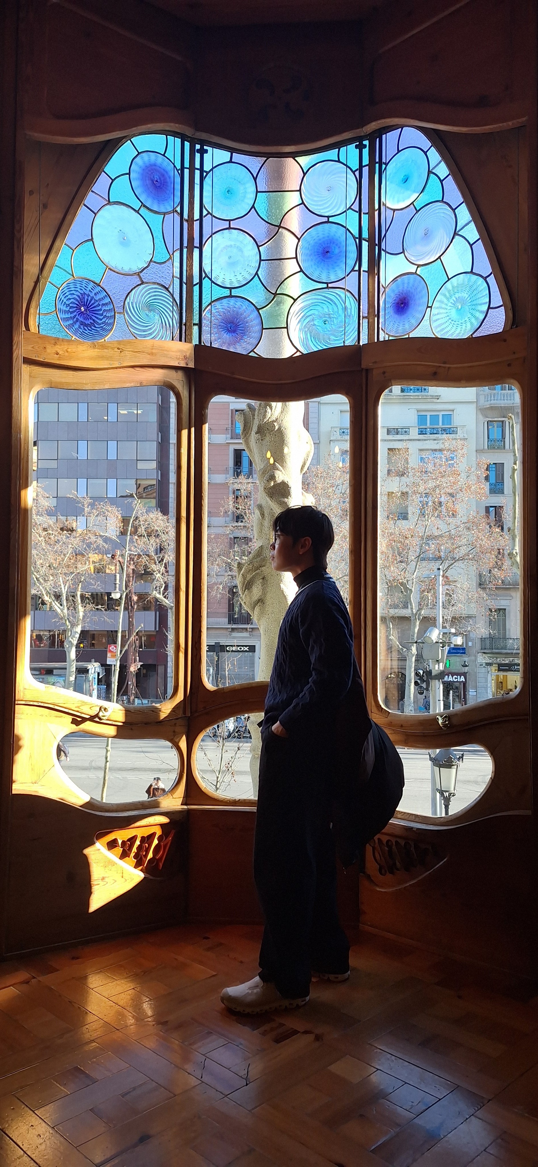 A person with short blonde hair holds a vintage camera.