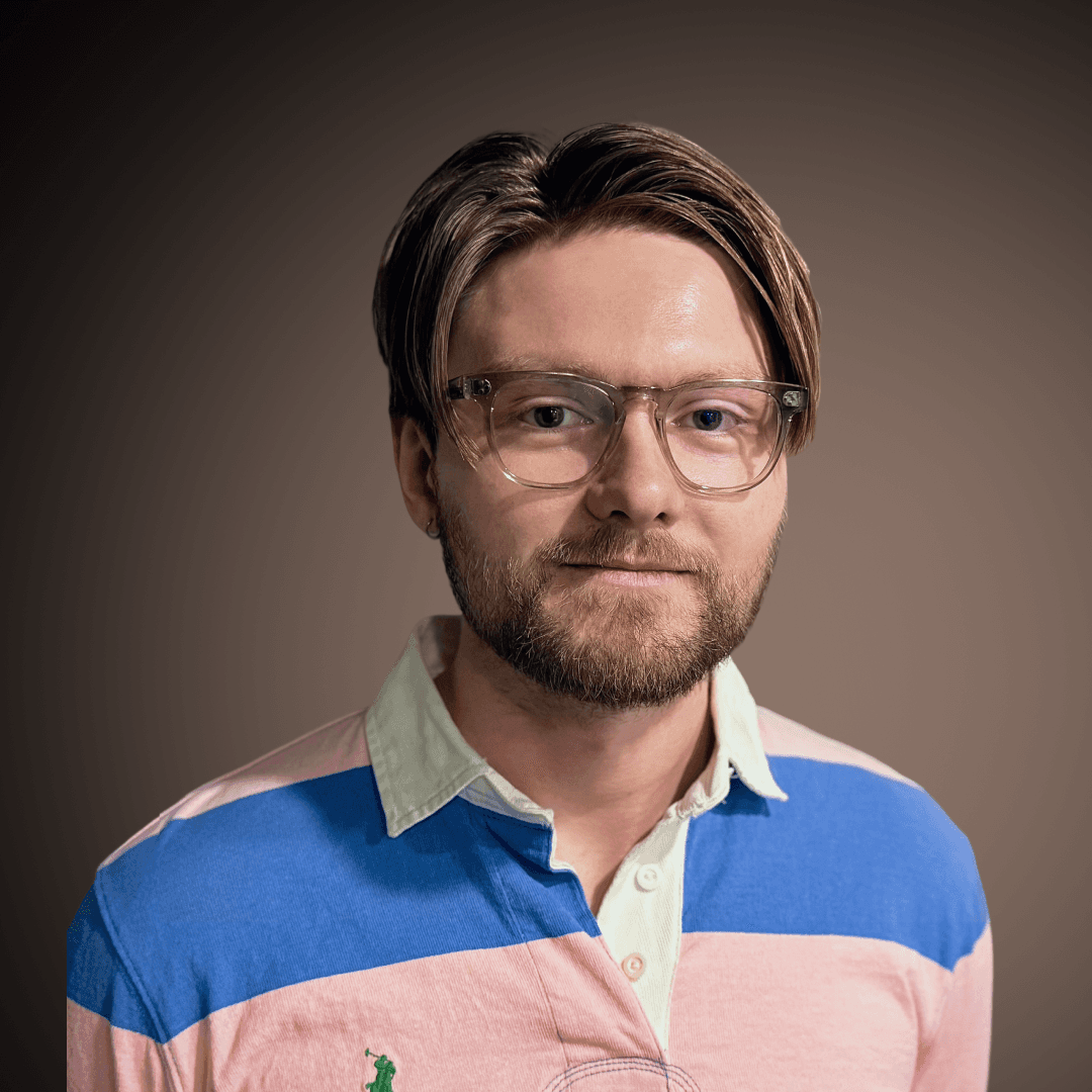 Portrait of a person in a pink sweater against a light background