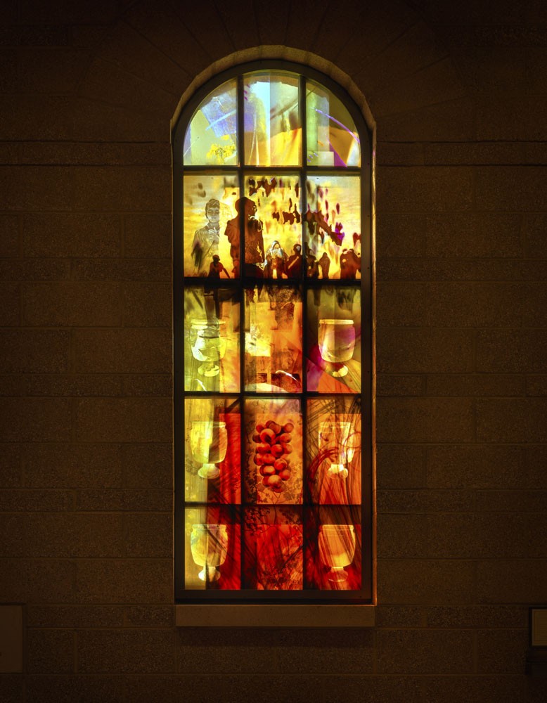 Liturgical stained glass window with Eucharistic symbolism and layered color, custom church commission using painterly glass techniques