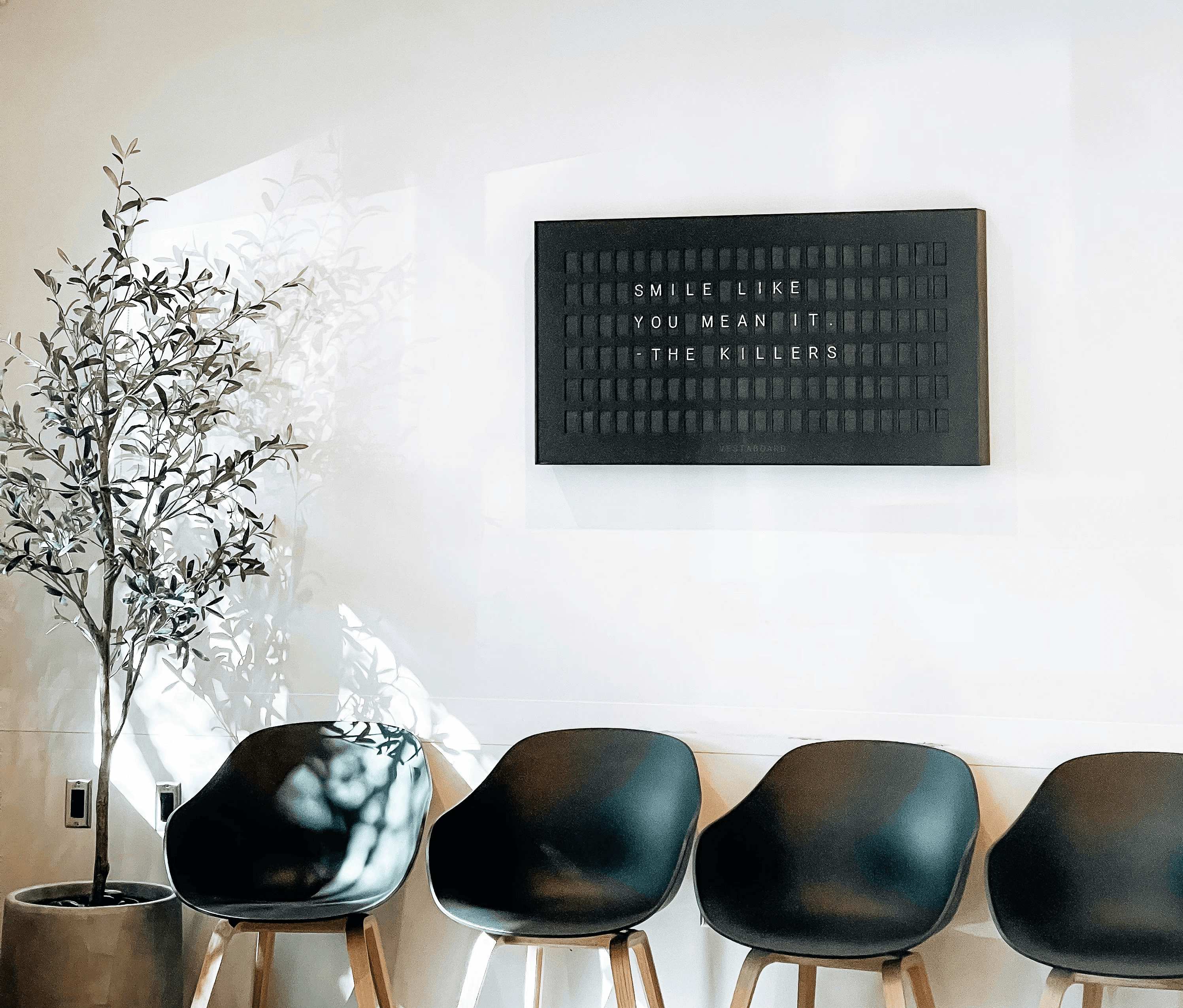 Modern waiting room with chairs and inspirational sign.