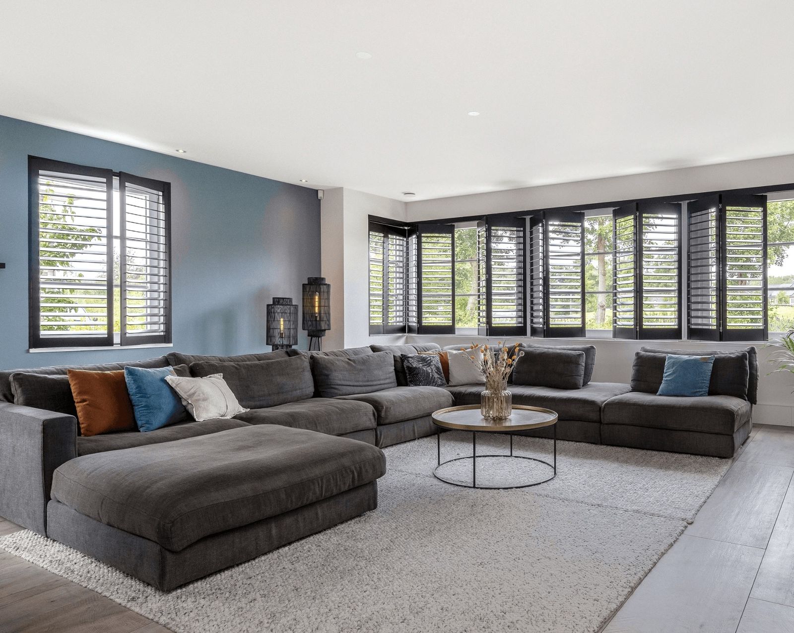 grote elementenbank grijs, blauwe muren, zwarte shutters