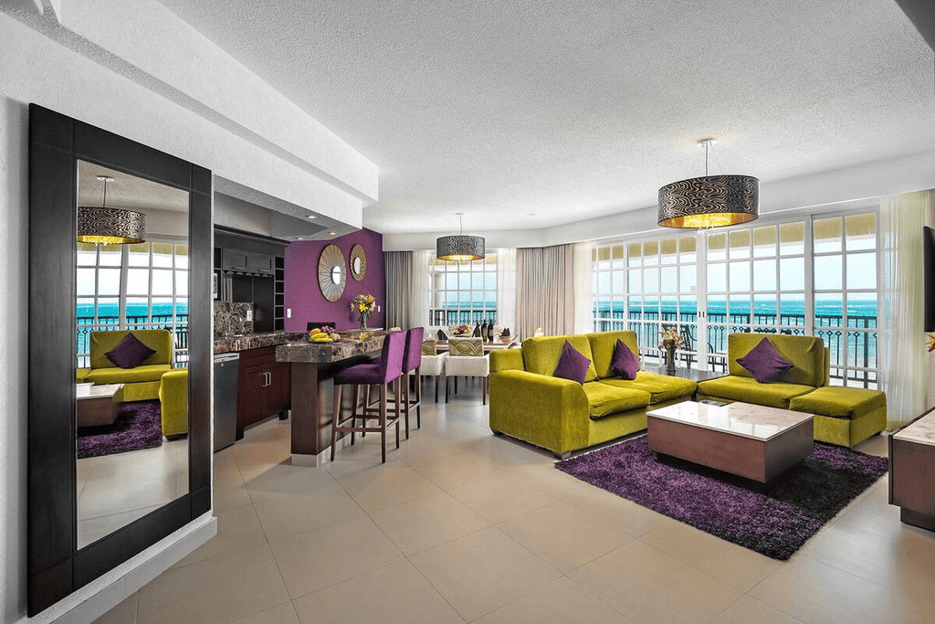 Couple standing on a balcony with binoculars in hand looking out over the ocean