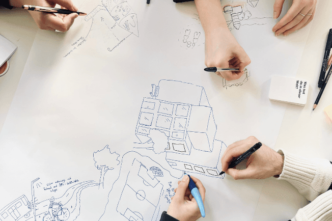 Worldbuilding: mehrere Personen gestalten ein Worldbuilding-Plakat