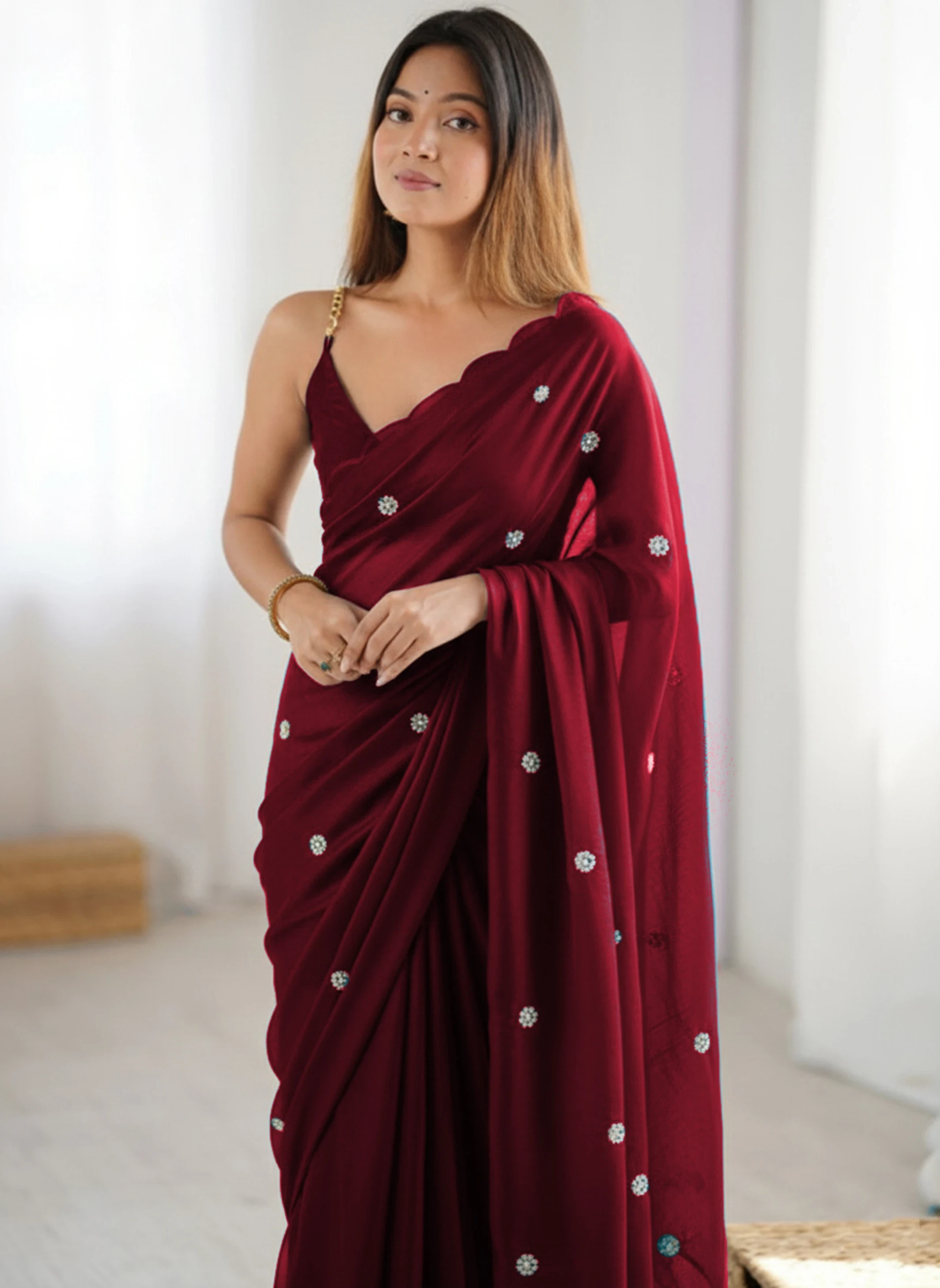 Woman in a maroon saree with a scalloped blouse