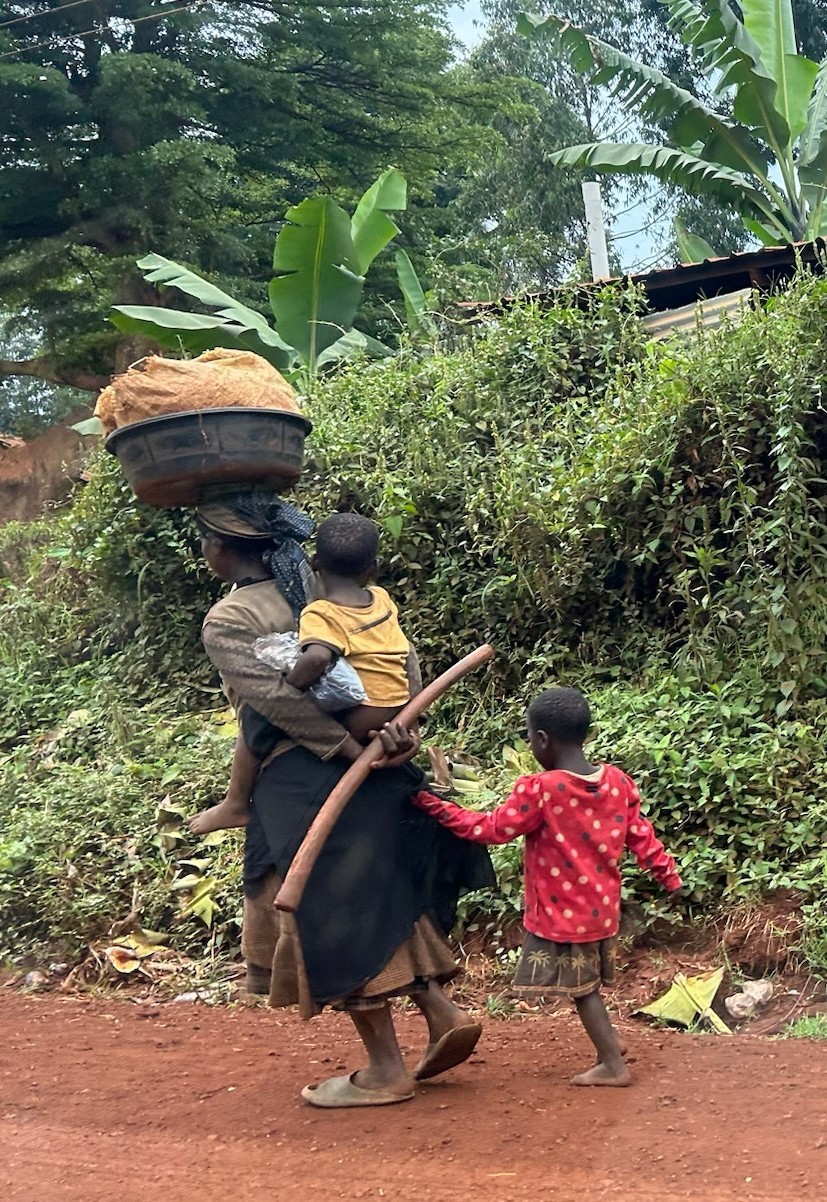 Three children walk along a dirt path.