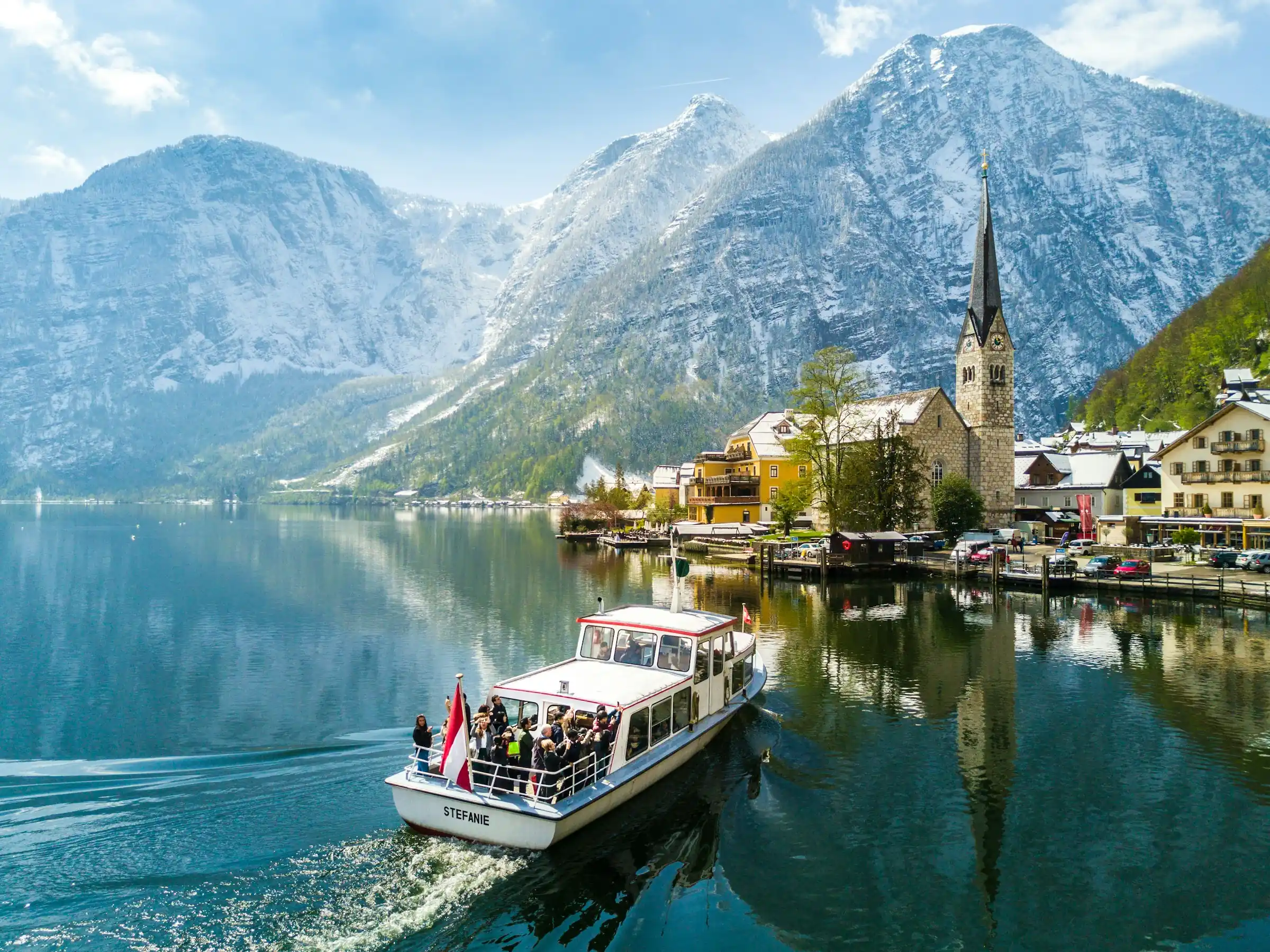Österreich, Hallstatt am Hallstätter See mit Bergkulisse und Schiff, klarer Himmel (Salzkammergut)