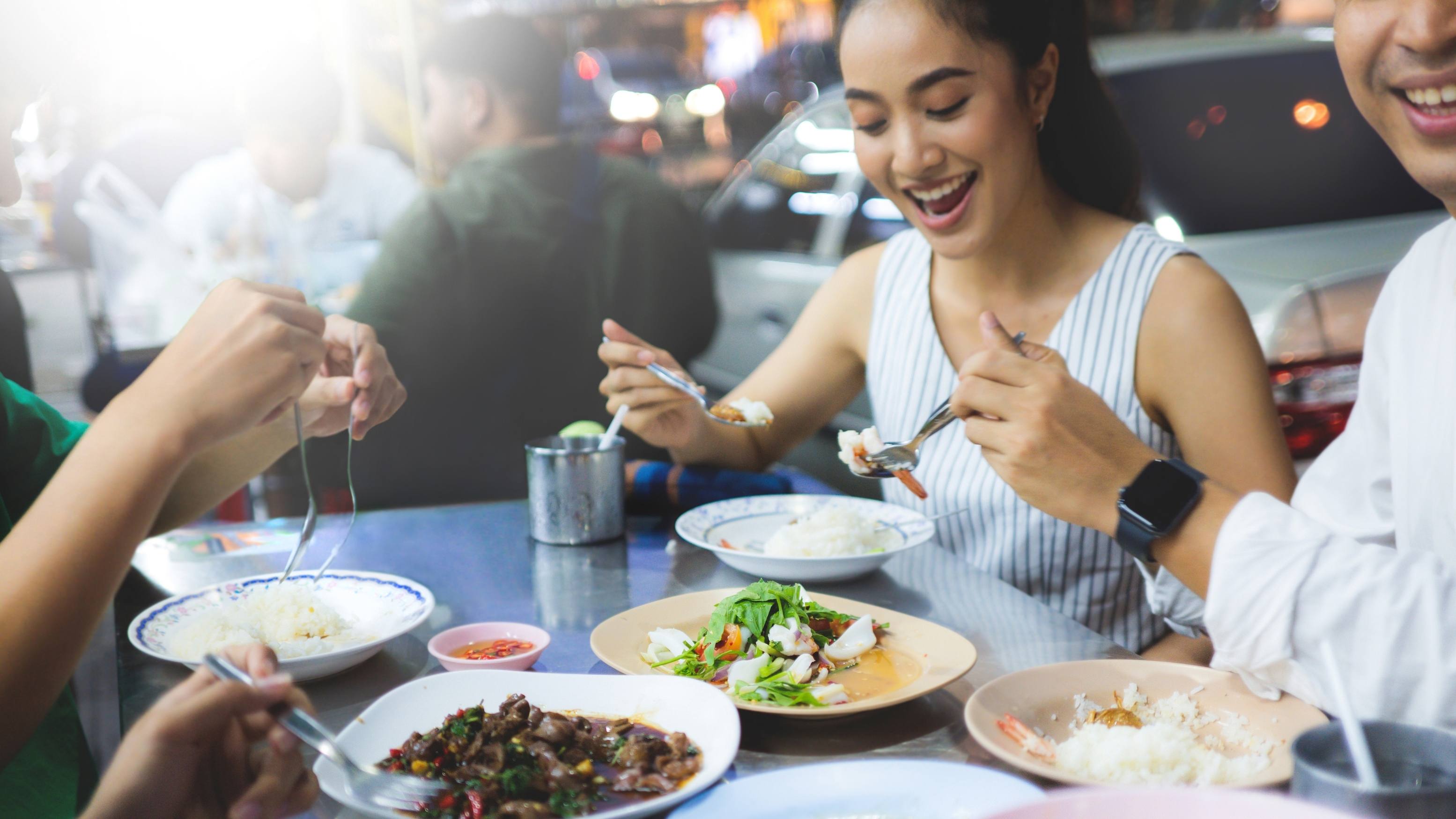 一群开心的顾客在餐厅用餐并露出笑容