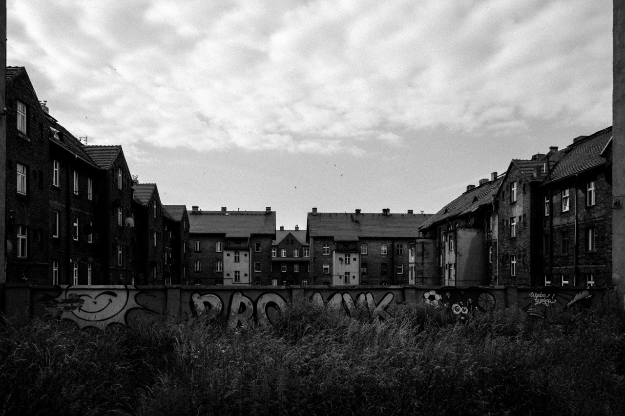 Black and white documentary shot of old brick tenement houses (familoki) in Lipiny, Silesia.