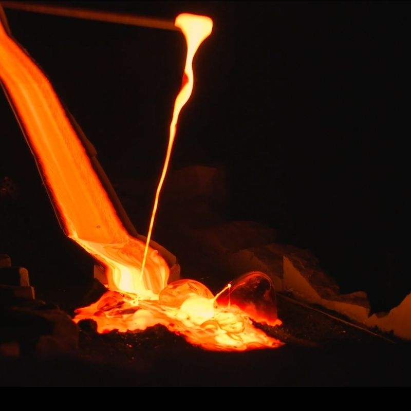 Close-up of glowing molten lava flowing during a live demonstration at Lava Show in Iceland, revealing the bright orange lava stream, fluid movement and intense heat as it cools into volcanic rock.