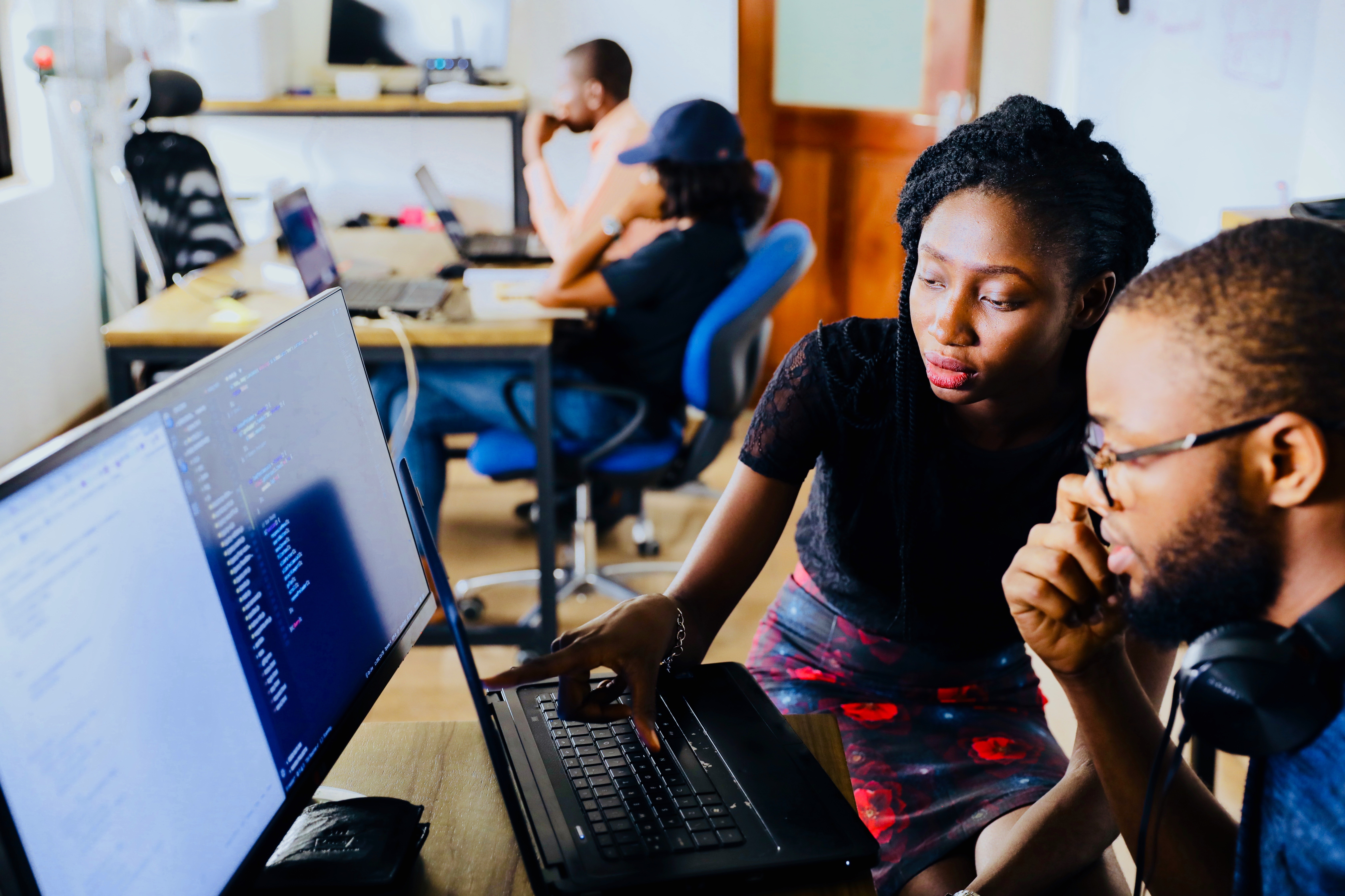 Two members of a team looking data on a computer screen