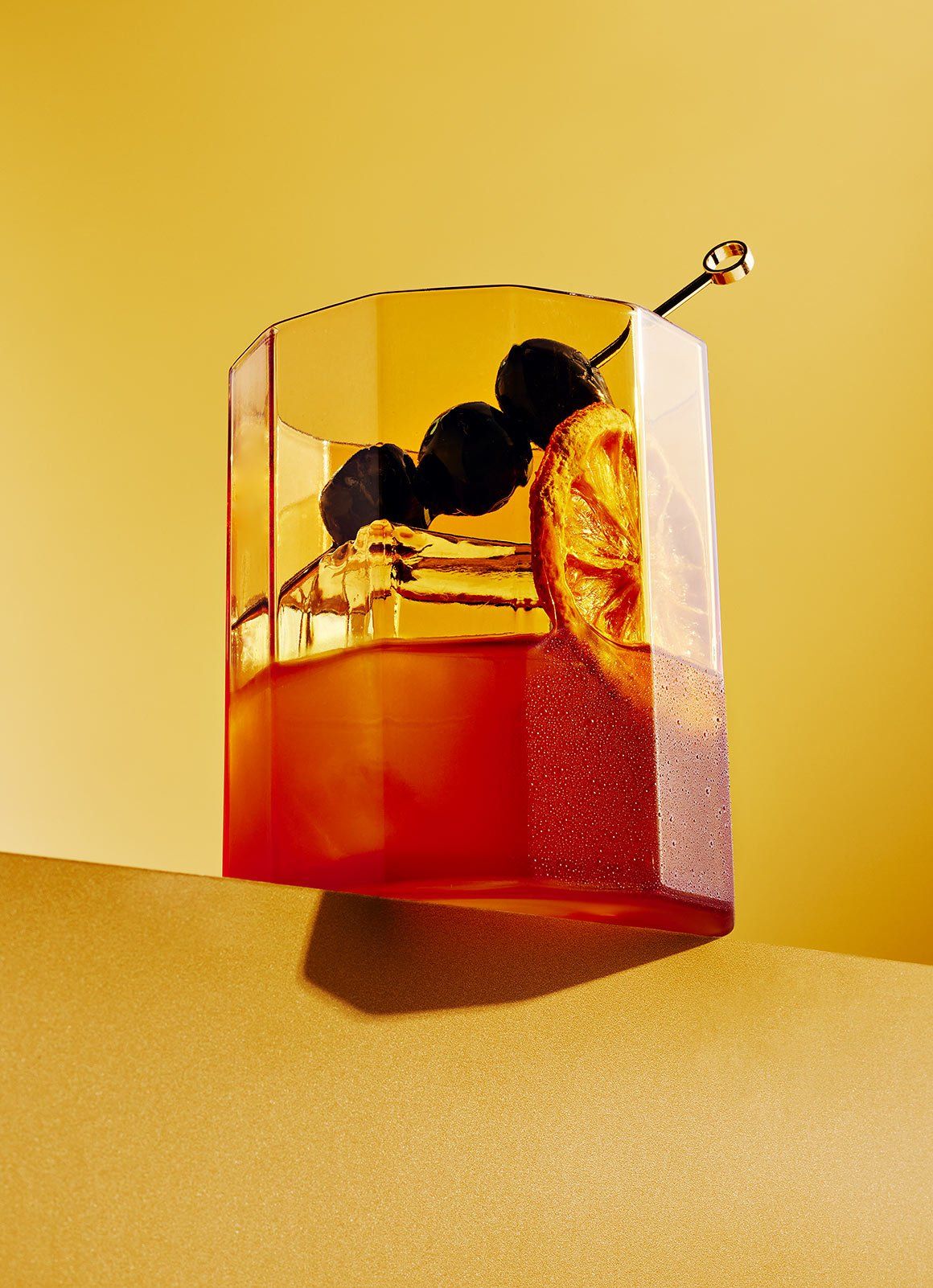 Artfully styled amber cocktail with citrus and dark cherries, symbolizing the precision, balance, and flavor layering in Dhoom’s contemporary Indian cocktails.