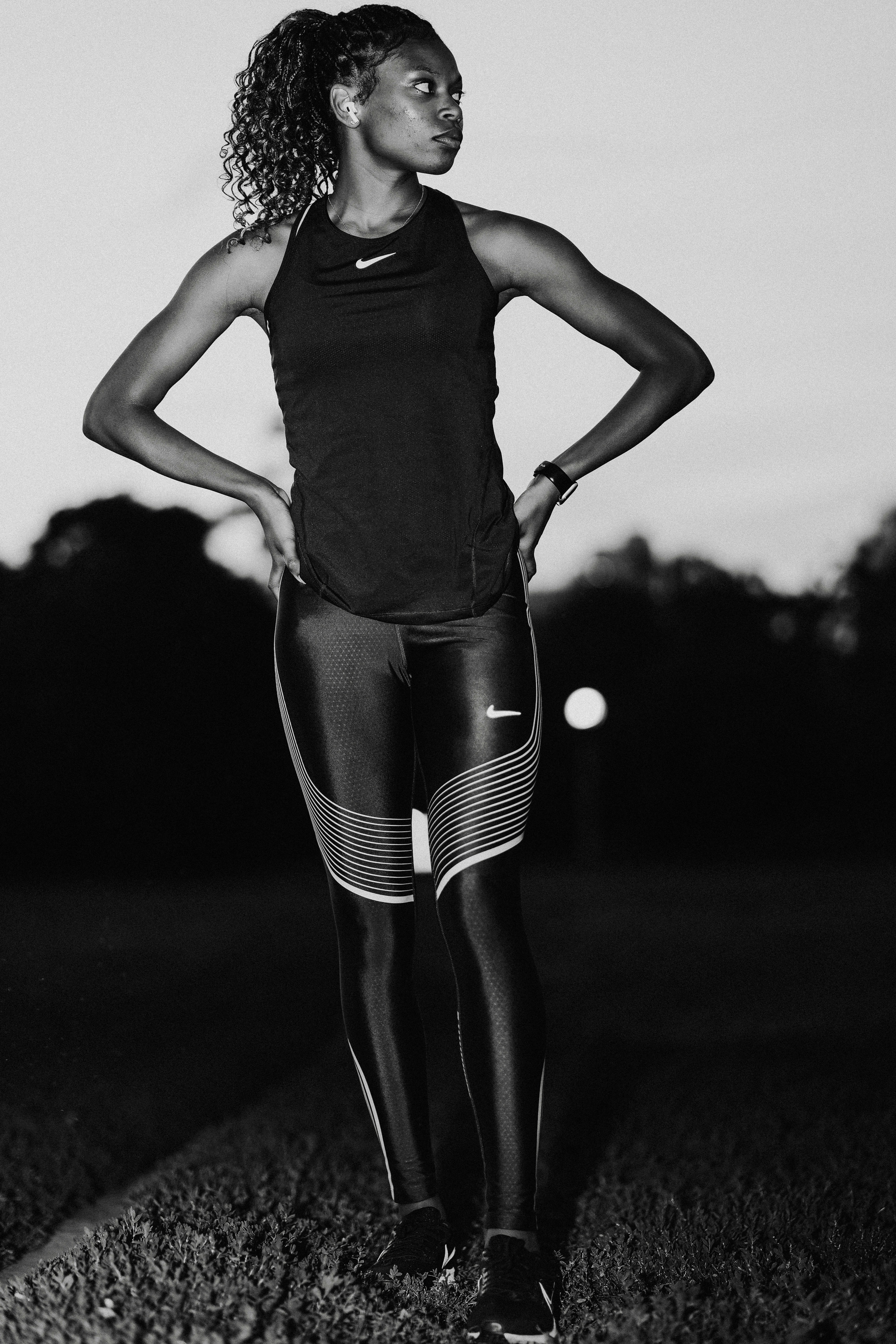 A black and white photo of a woman standing in a field