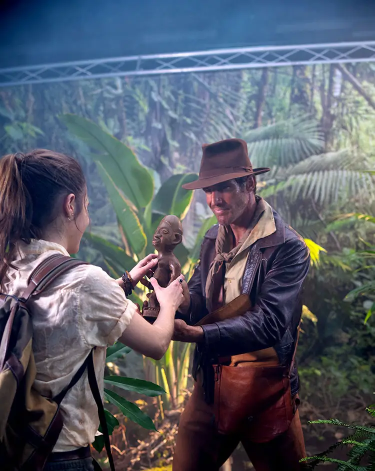 Portfolio Thankium: Exploradores en la selva sostienen una figura antigua.