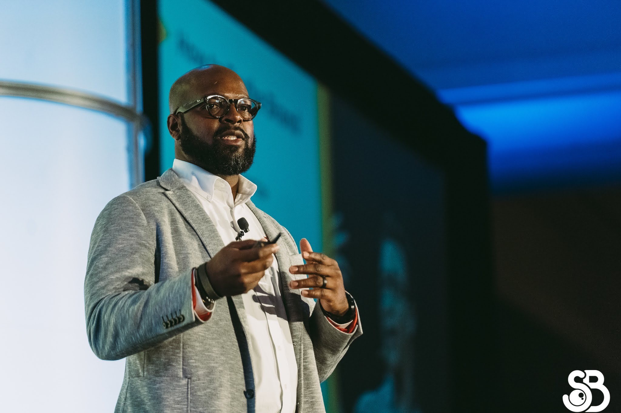 man on stage talking to an audience