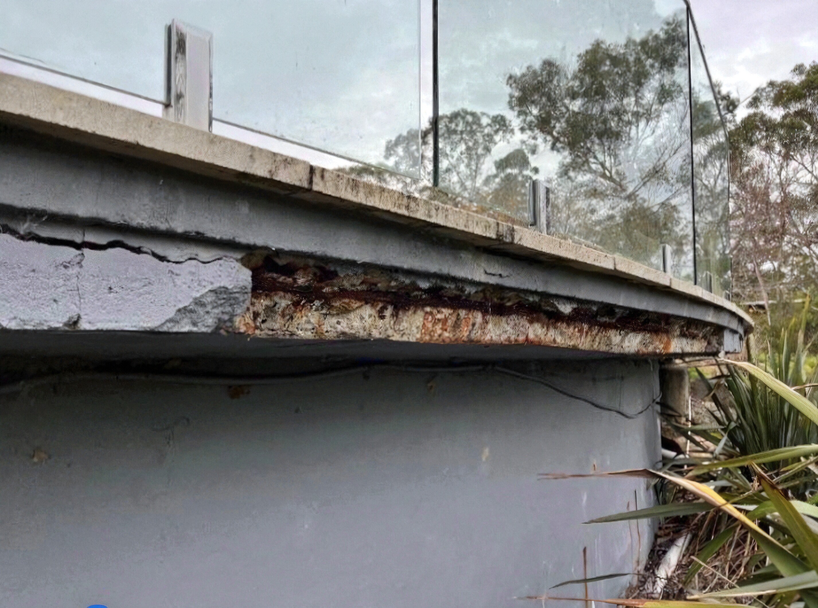 Modern kitchen with a wooden dining table, white chairs, and a hanging light fixture above.