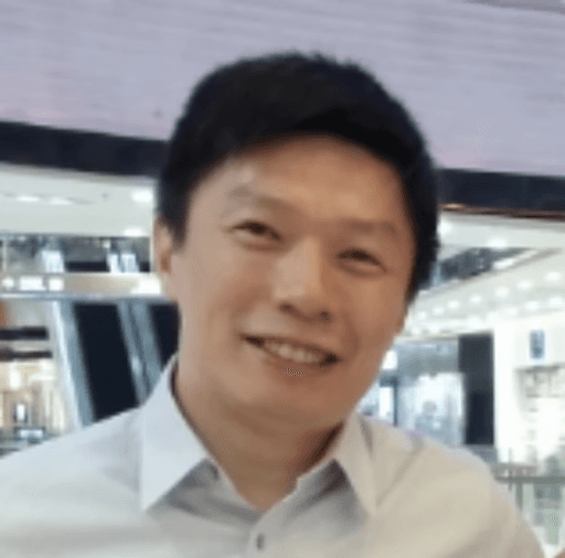 smiling man wearing black turtleneck shirt holding camrea