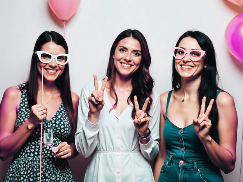 Three females showing the 'peace sign' in a photo booth