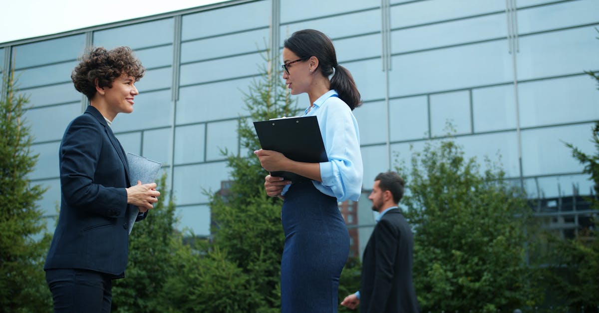 Business professionals engaged in conversation outside a modern office building.