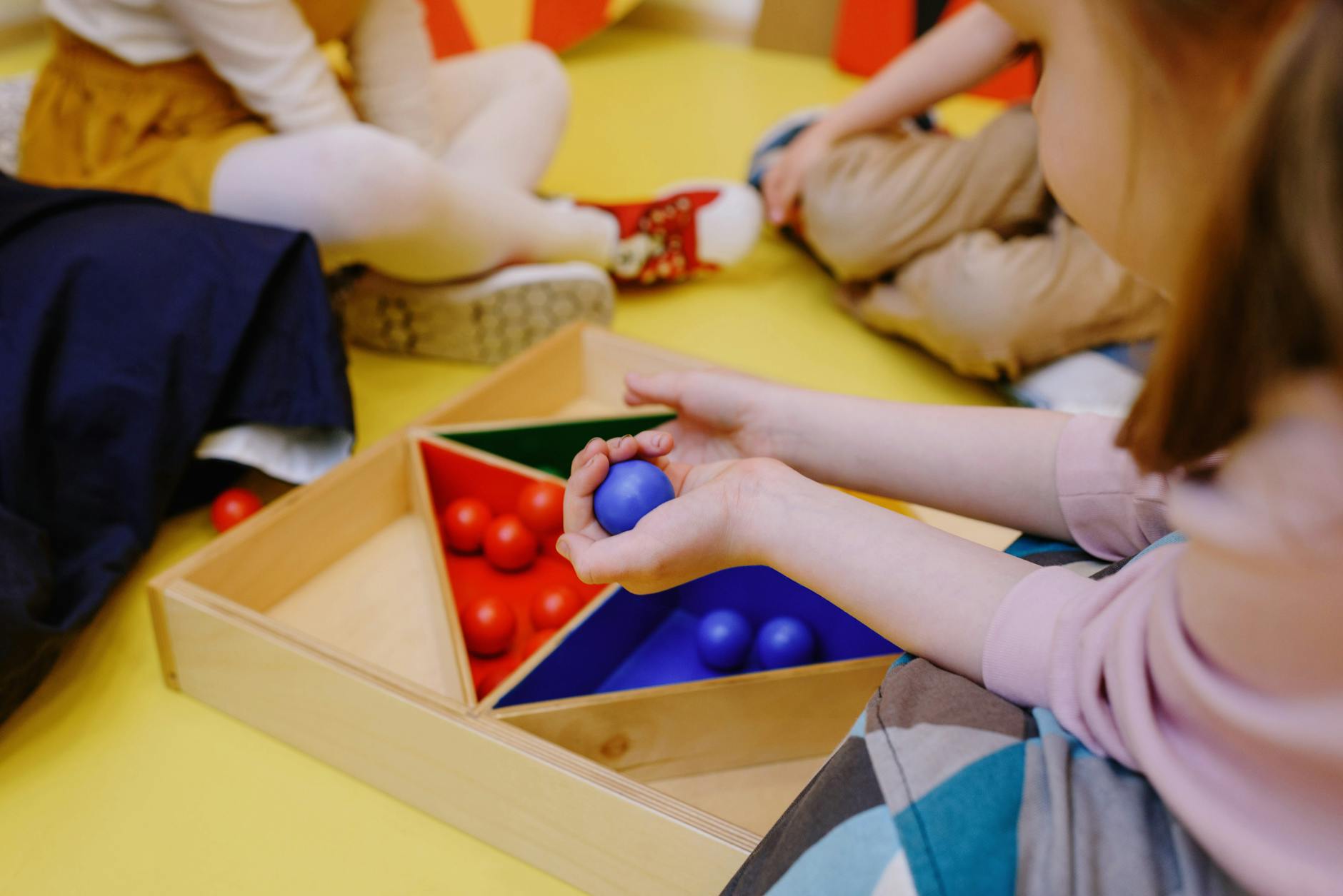 A kindergarten teacher standing in a colorful classroom featuring a reading rug and cubbies for a letter from your teacher.